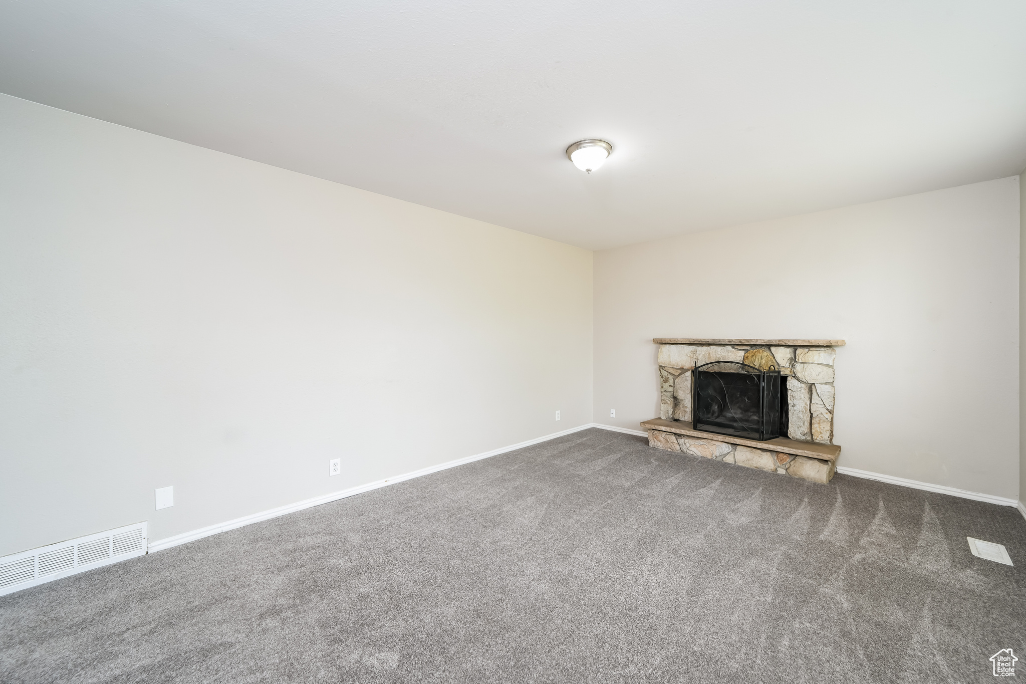 Unfurnished living room with a fireplace and carpet