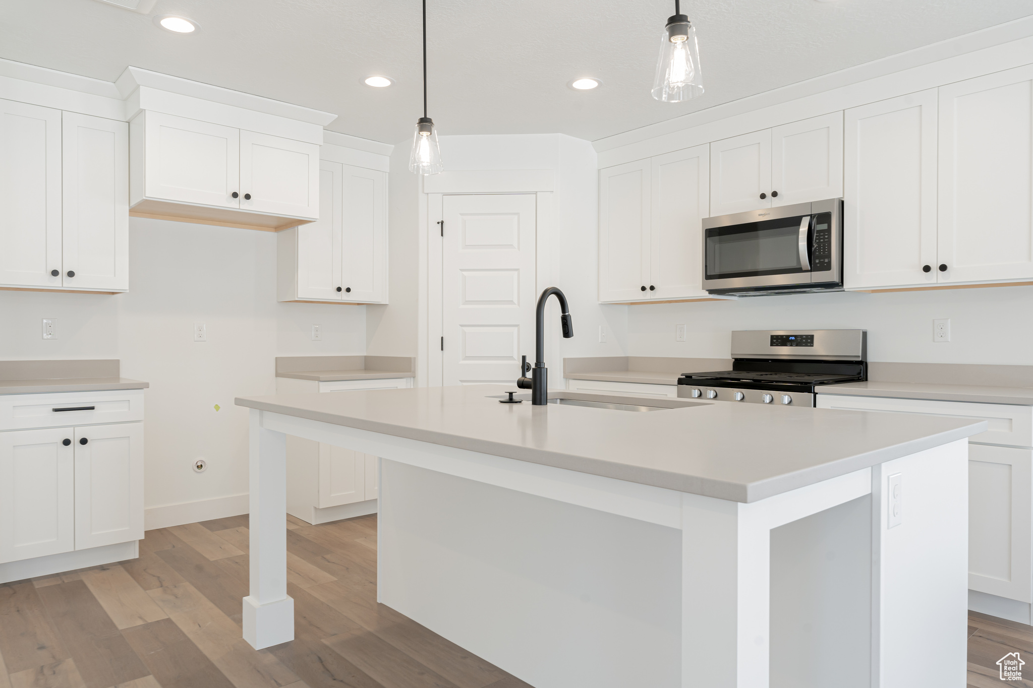 Kitchen featuring light hardwood / wood-style floors, sink, an island with sink, and stainless steel appliances