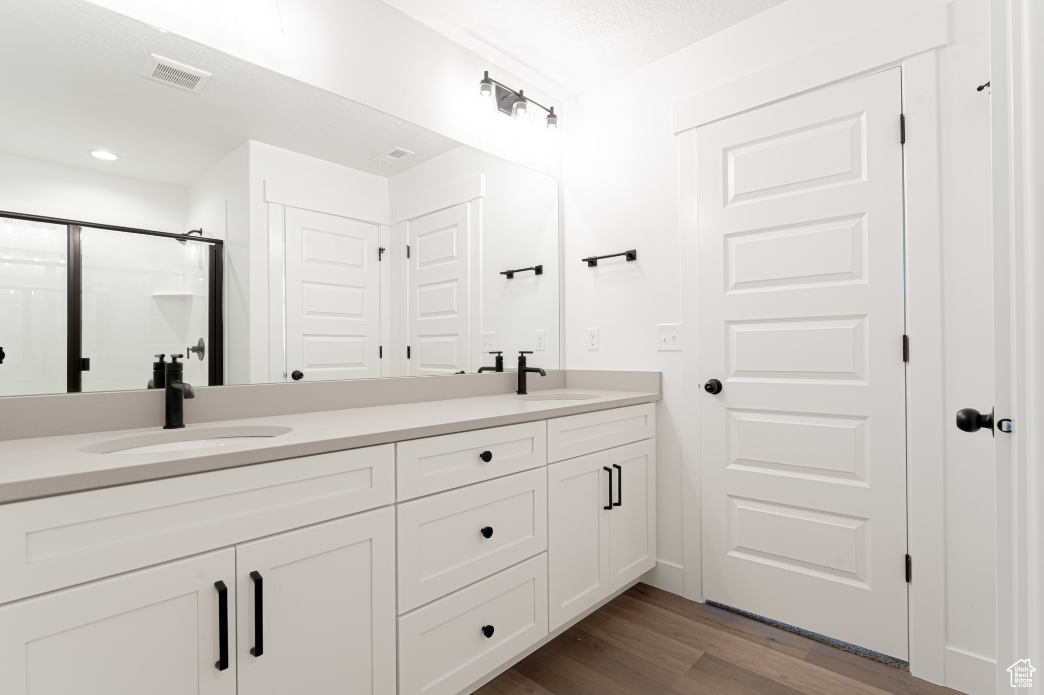 Bathroom featuring double vanity and wood-type flooring