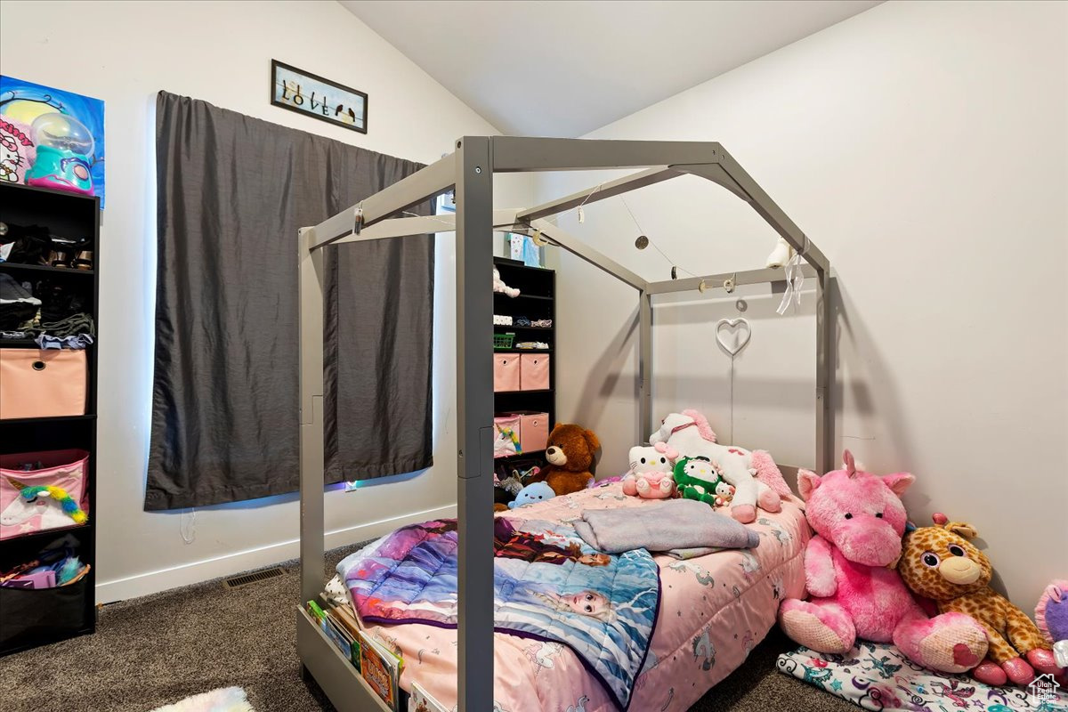 Carpeted bedroom with lofted ceiling