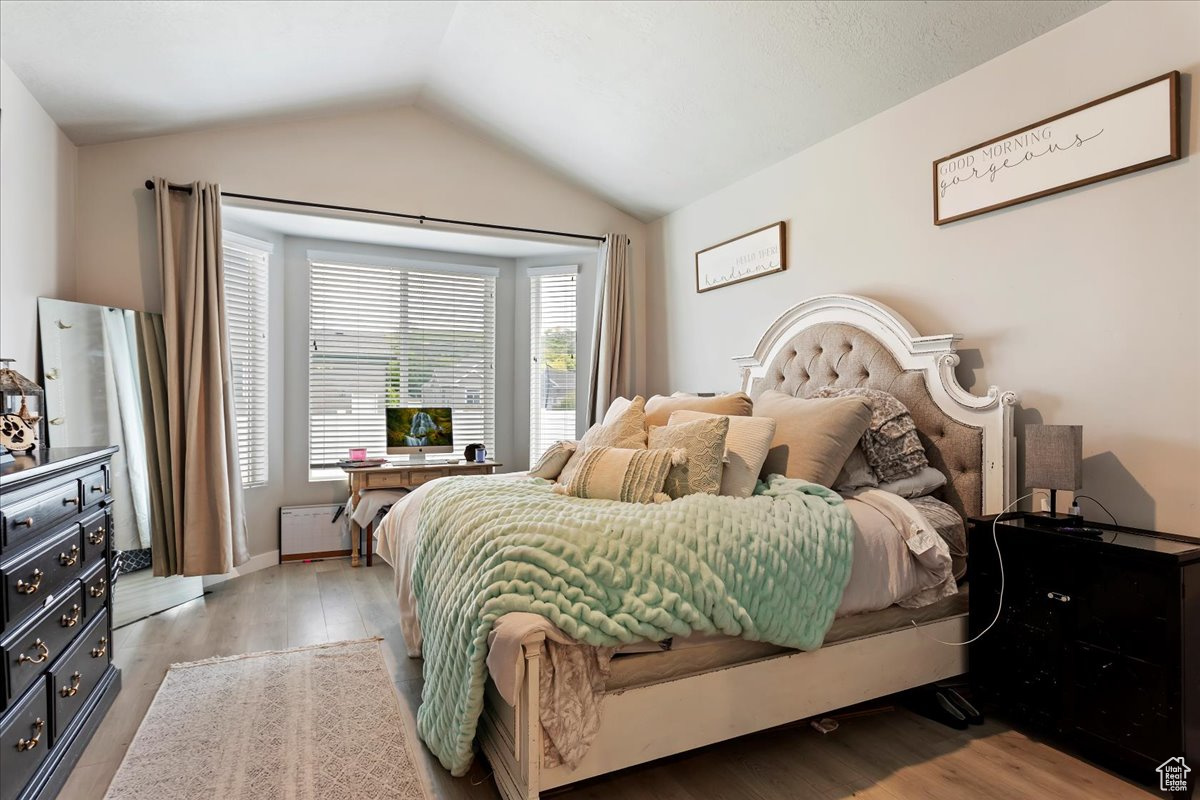 Bedroom featuring light hardwood / wood-style flooring and vaulted ceiling