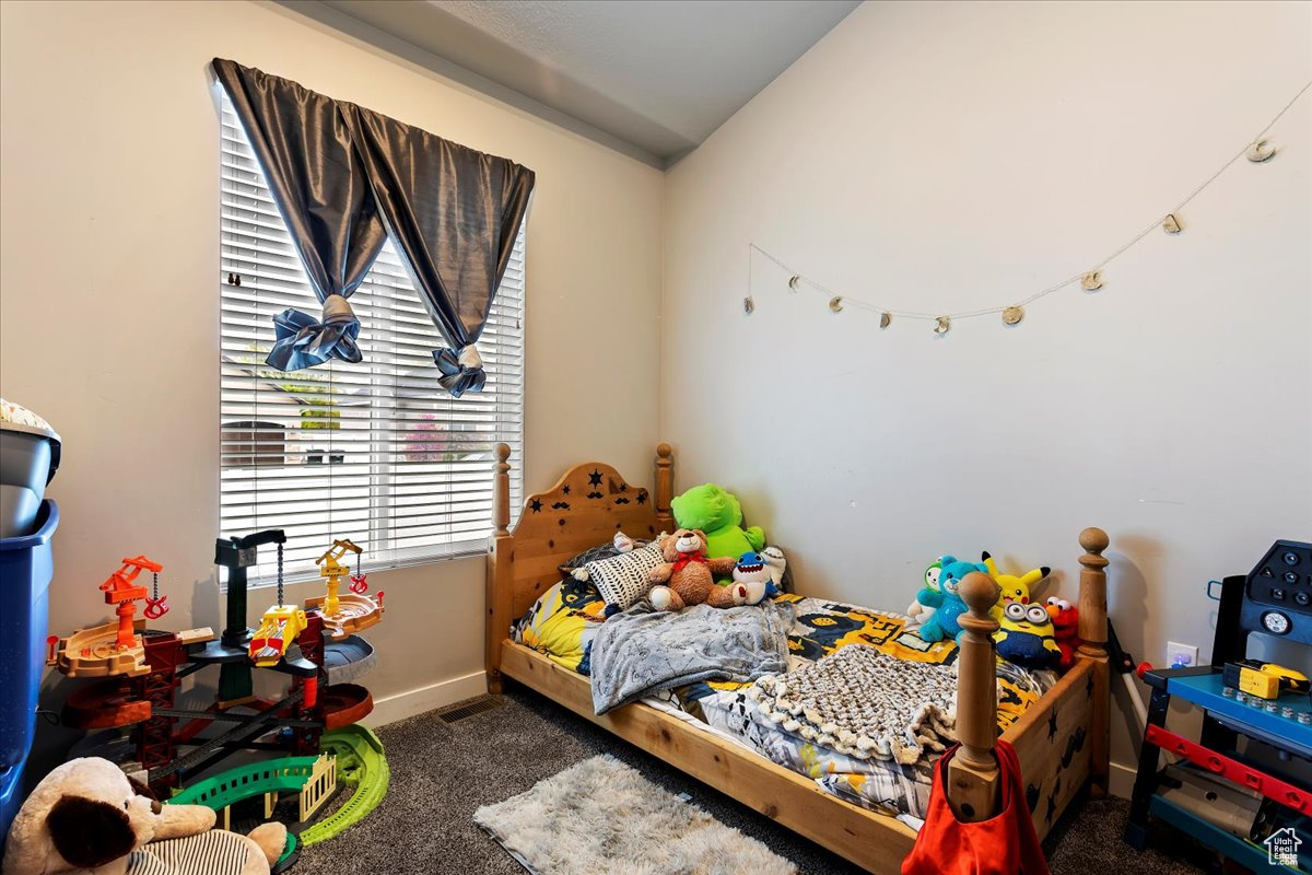 Carpeted bedroom with lofted ceiling