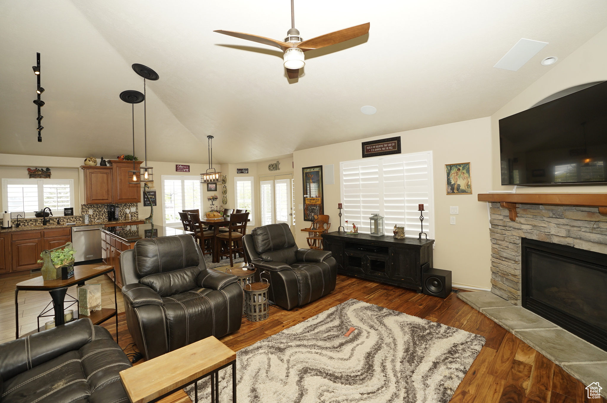 Living room featuring ceiling fan, vaulted ceiling, hardwood / wood-style flooring, a fireplace, and sink