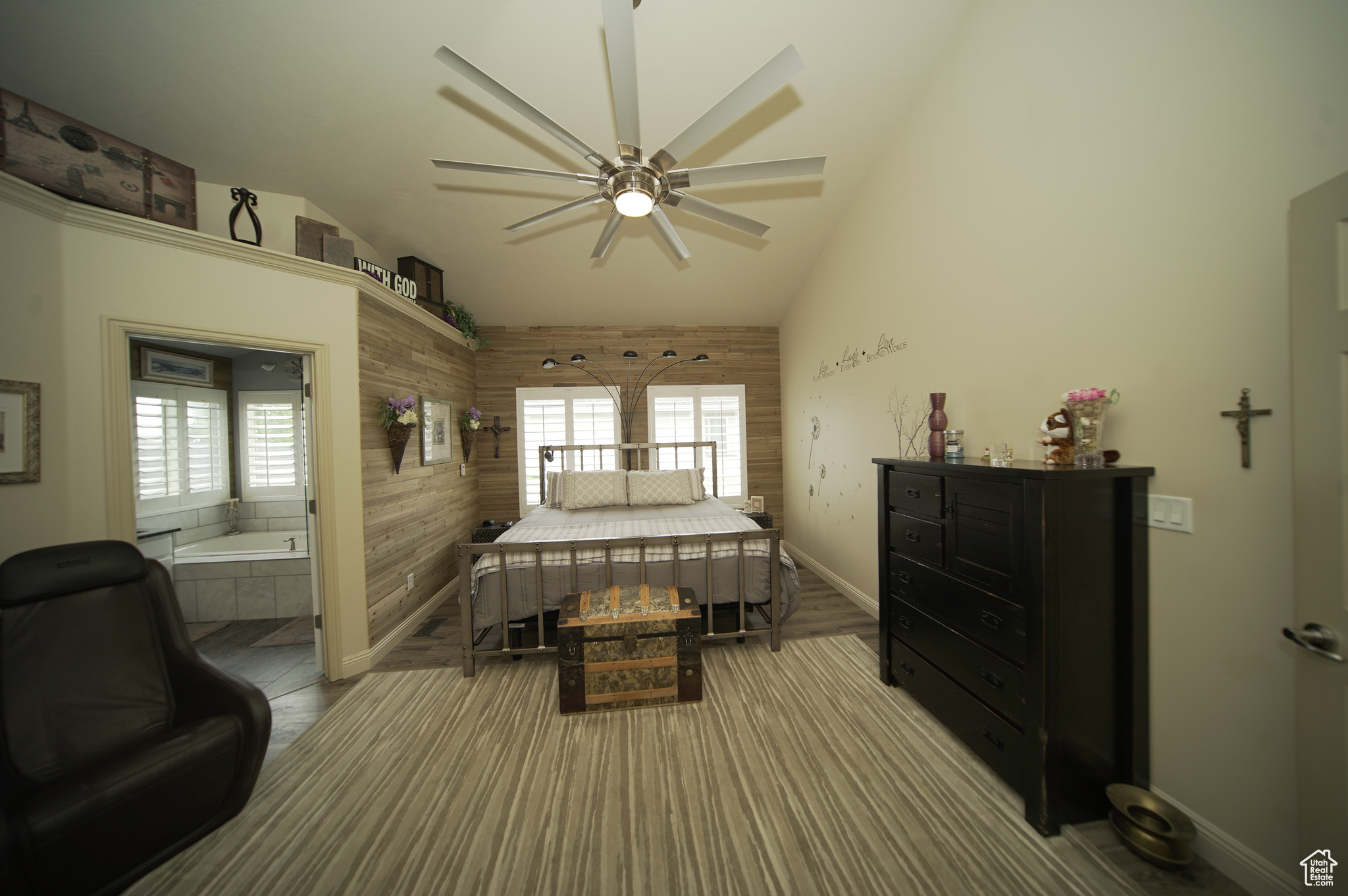 Bedroom with high vaulted ceiling, connected bathroom, and ceiling fan