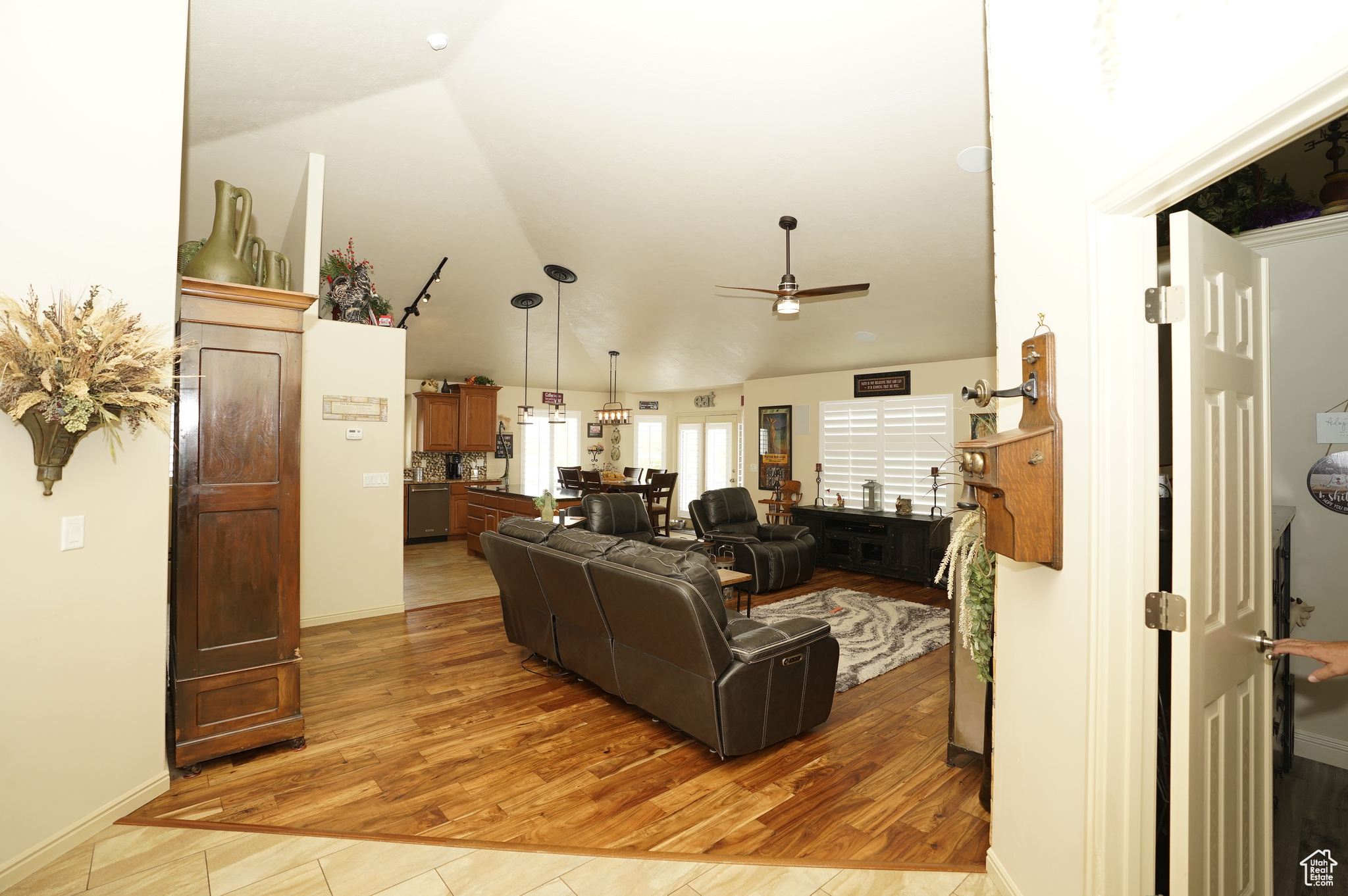 Living room with vaulted ceiling, ceiling fan, and hardwood / wood-style floors