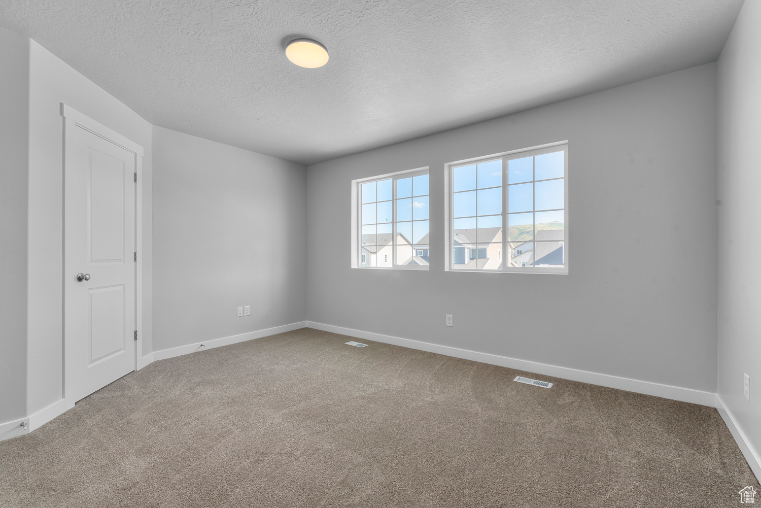 Carpeted empty room featuring a textured ceiling