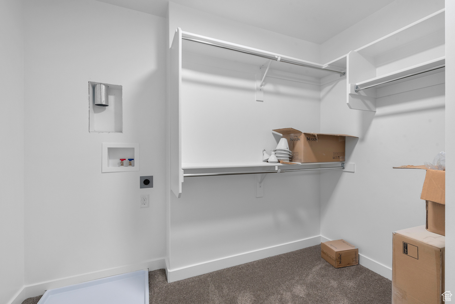 Spacious closet with dark carpet