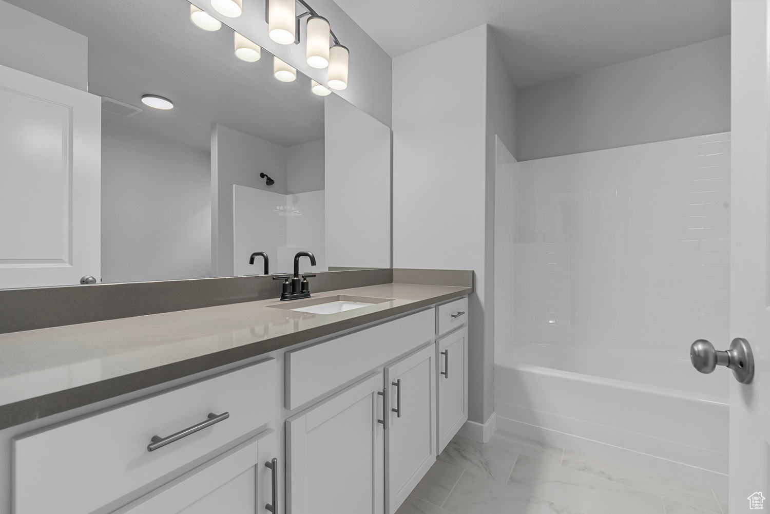 Bathroom featuring vanity, shower / washtub combination, and tile floors