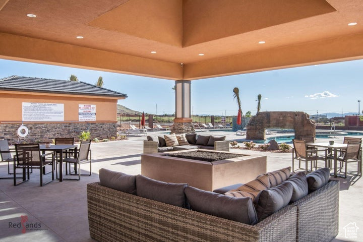 View of patio featuring a community pool and an outdoor living space with a fire pit