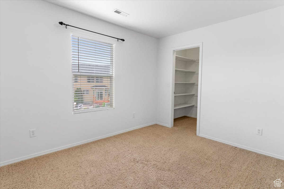Unfurnished room featuring carpet flooring and a wealth of natural light