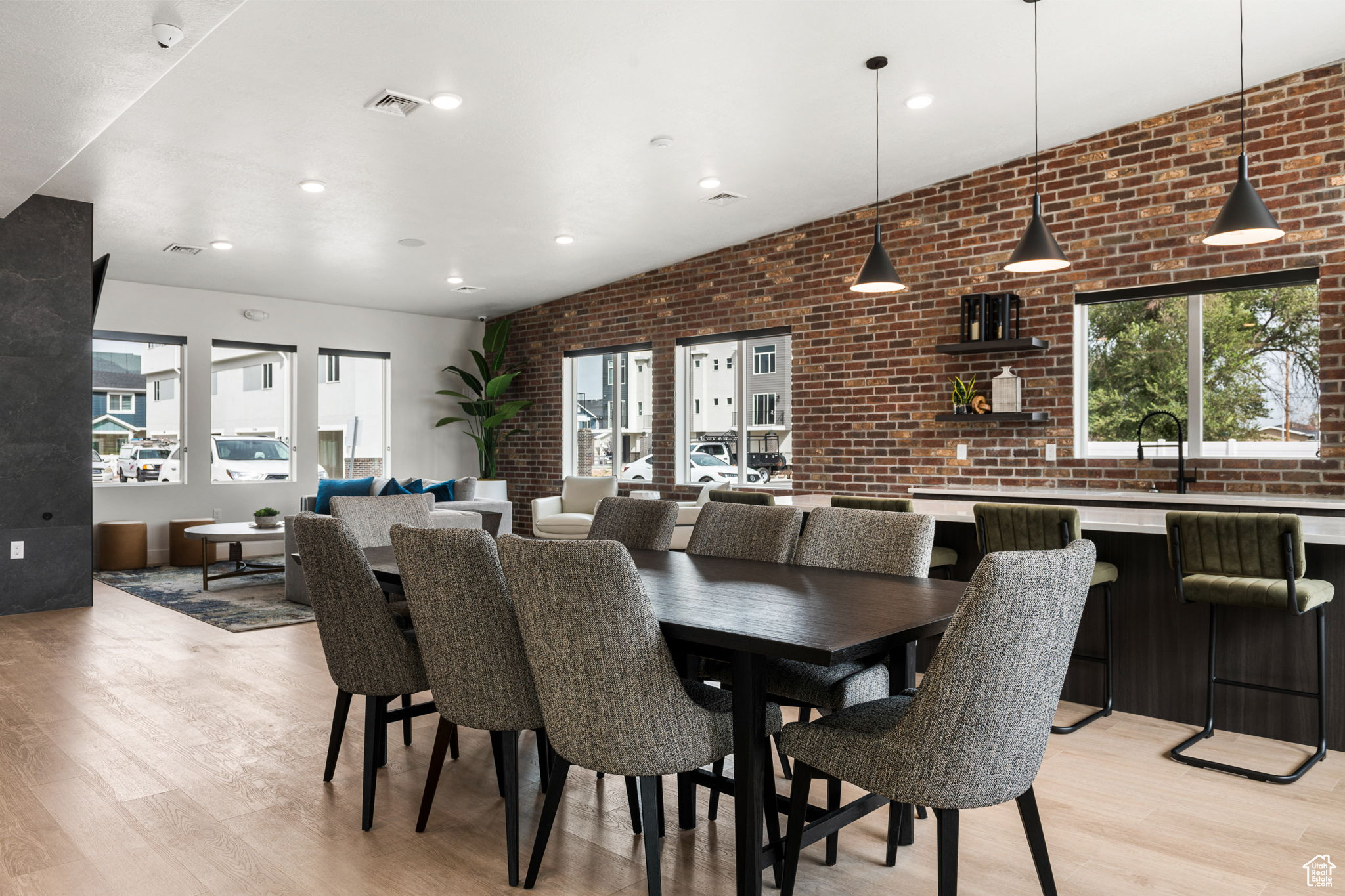 Dining space with brick wall and light hardwood / wood-style flooring