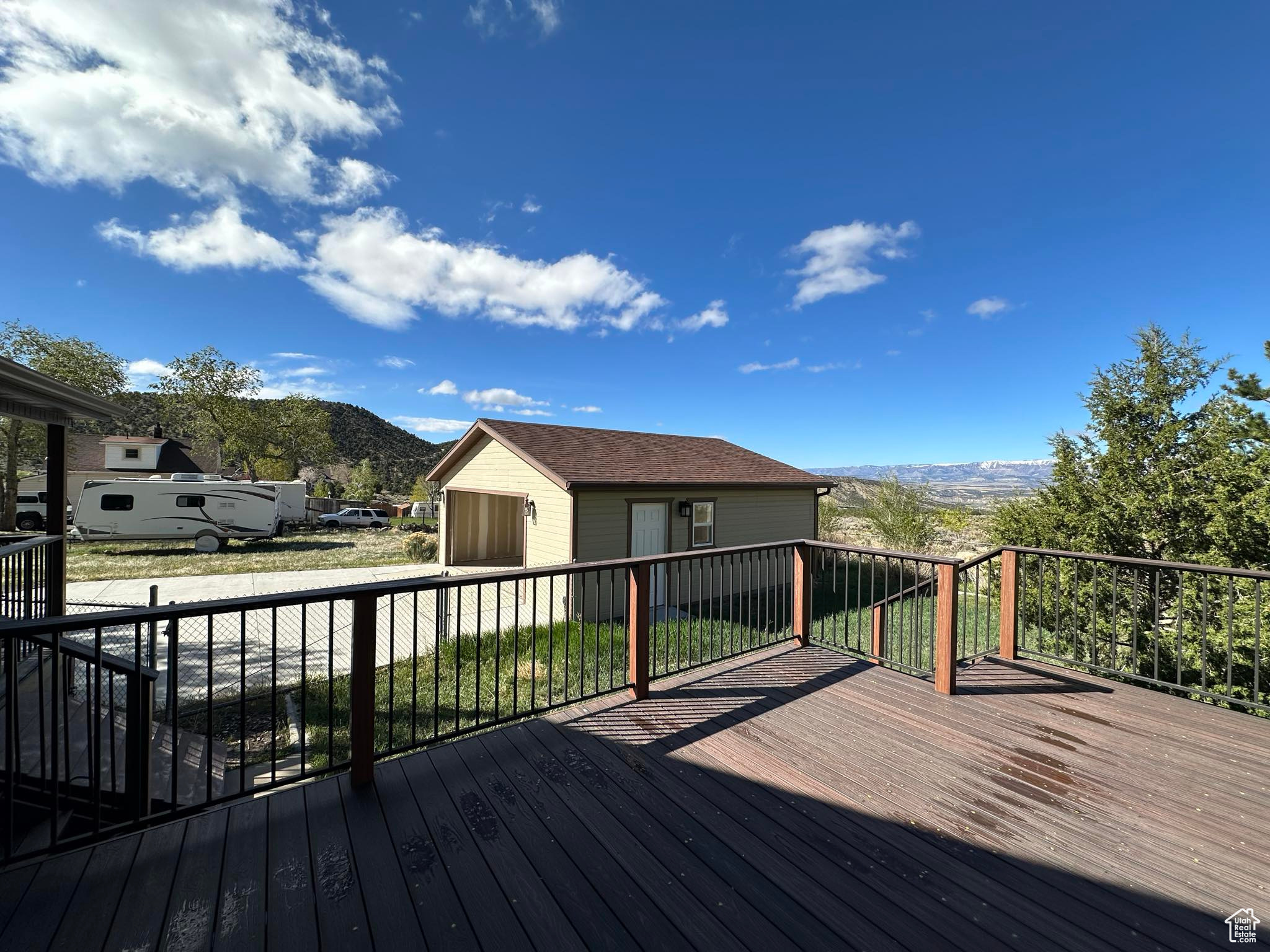 Wooden terrace featuring a mountain view and an outdoor structure