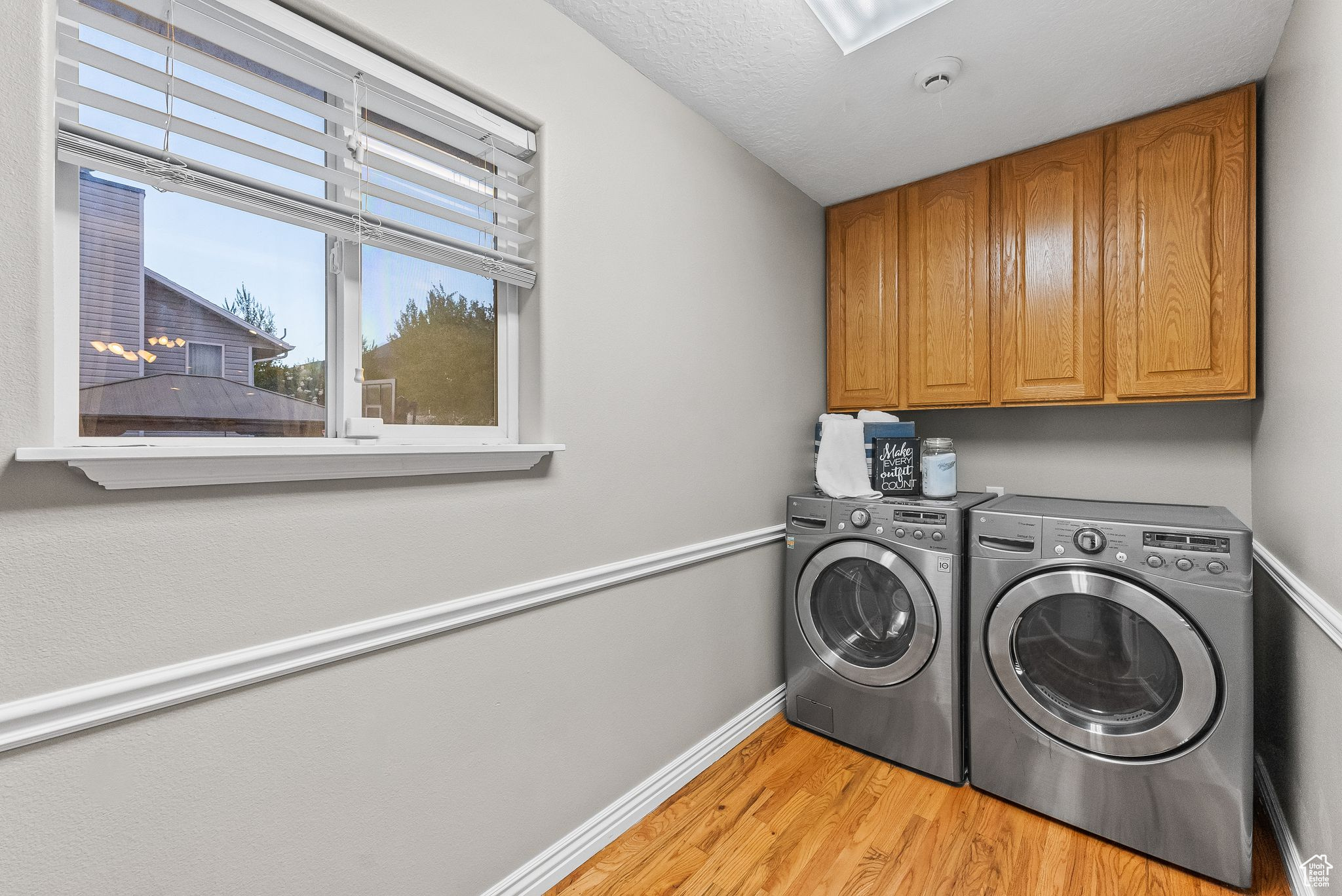 Laundry area featuring cabinets, independent washer and dryer, and light wood-type flooring