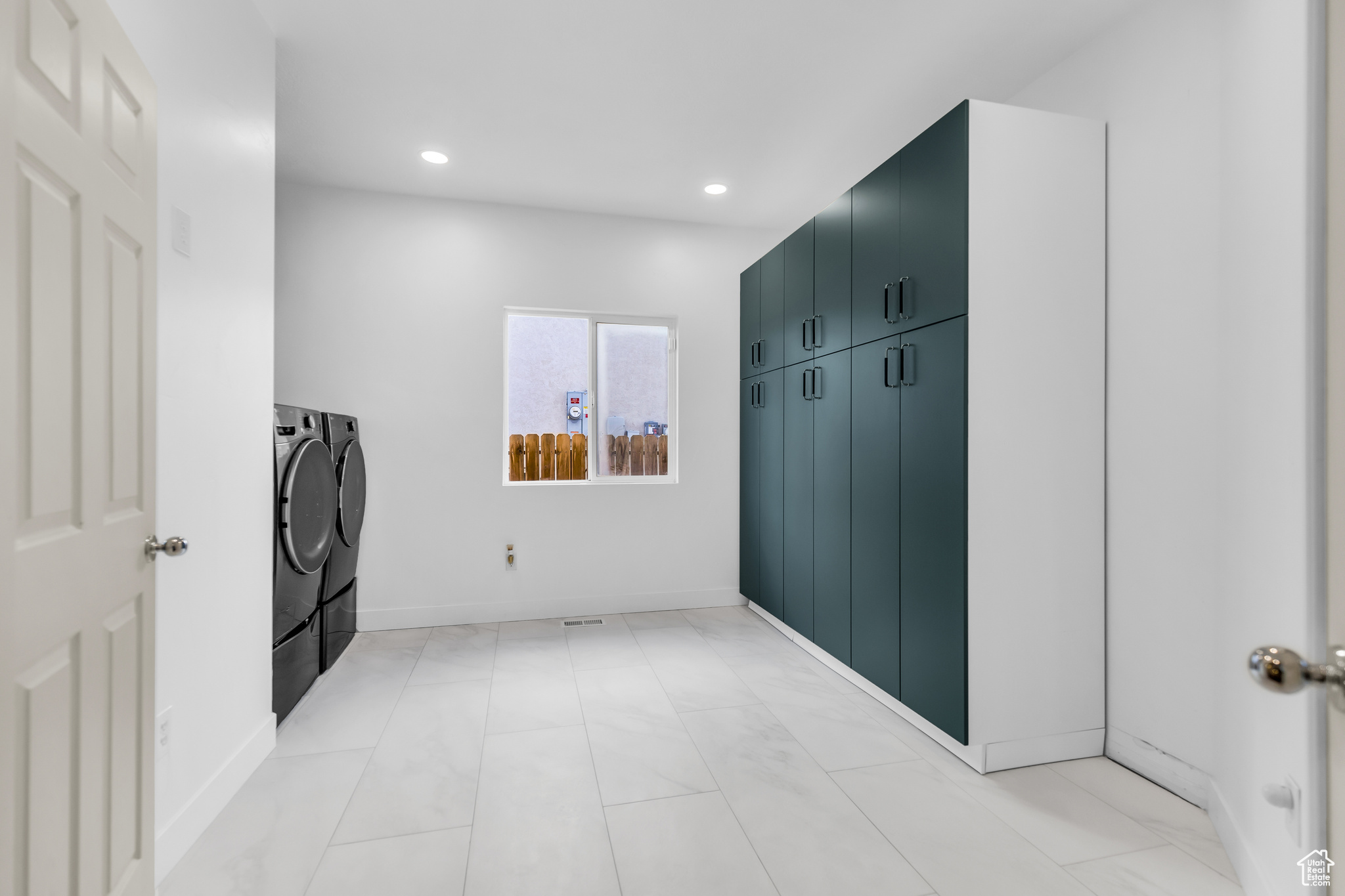Hall with light tile flooring and washer and dryer