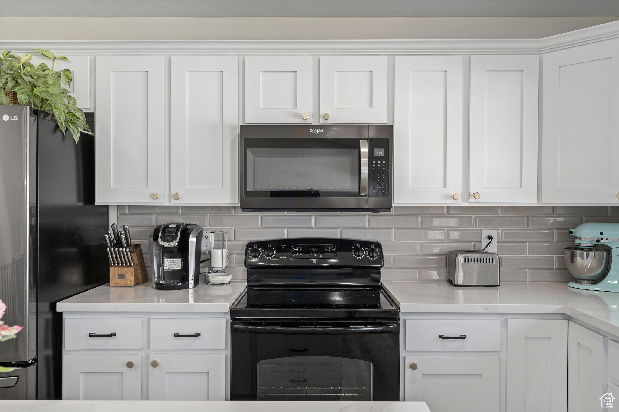 Kitchen featuring white cabinets, stainless steel appliances, and backsplash