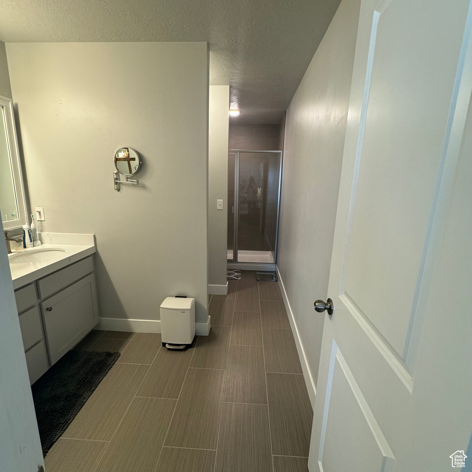 Bathroom with walk in shower, tile flooring, and vanity