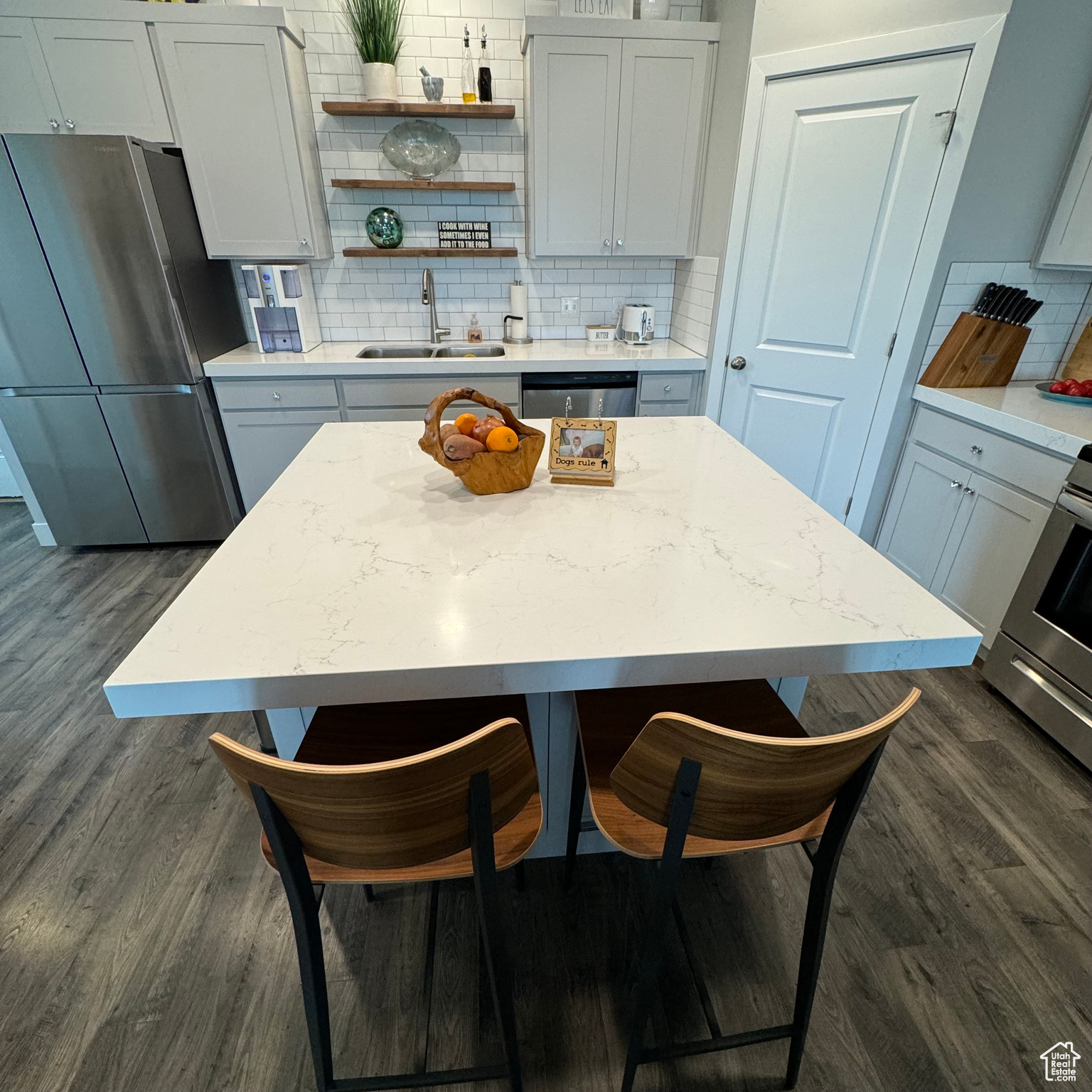 Kitchen featuring appliances with stainless steel finishes, tasteful backsplash, dark hardwood / wood-style flooring, and sink