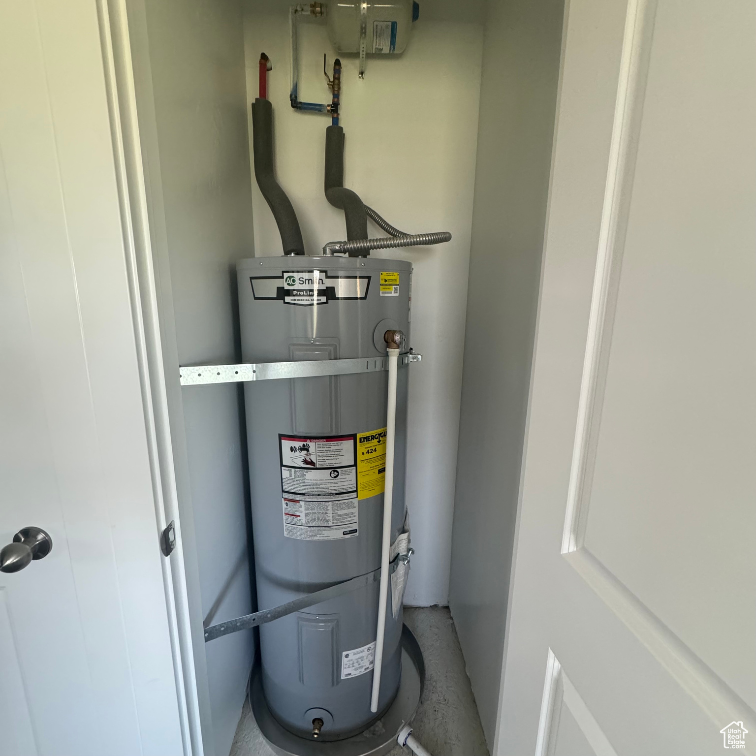 Utility room featuring secured water heater 50 gal.