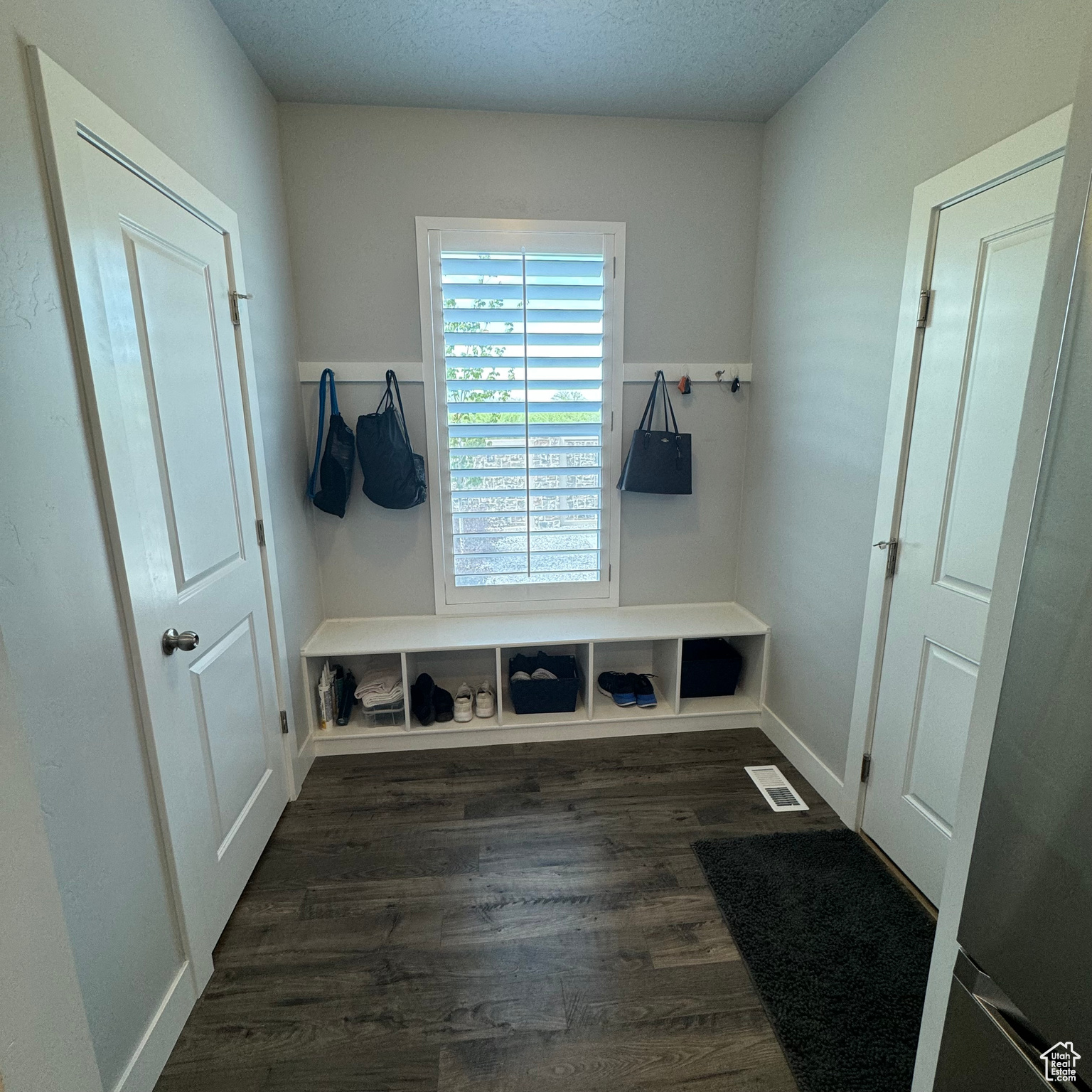 Mudroom with a textured ceiling and dark hardwood / wood-style flooring