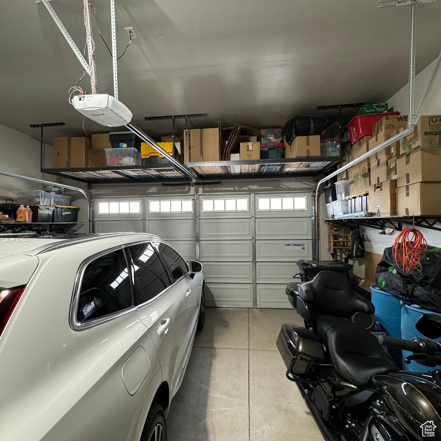 Garage with a garage door opener. Above garage door shelving