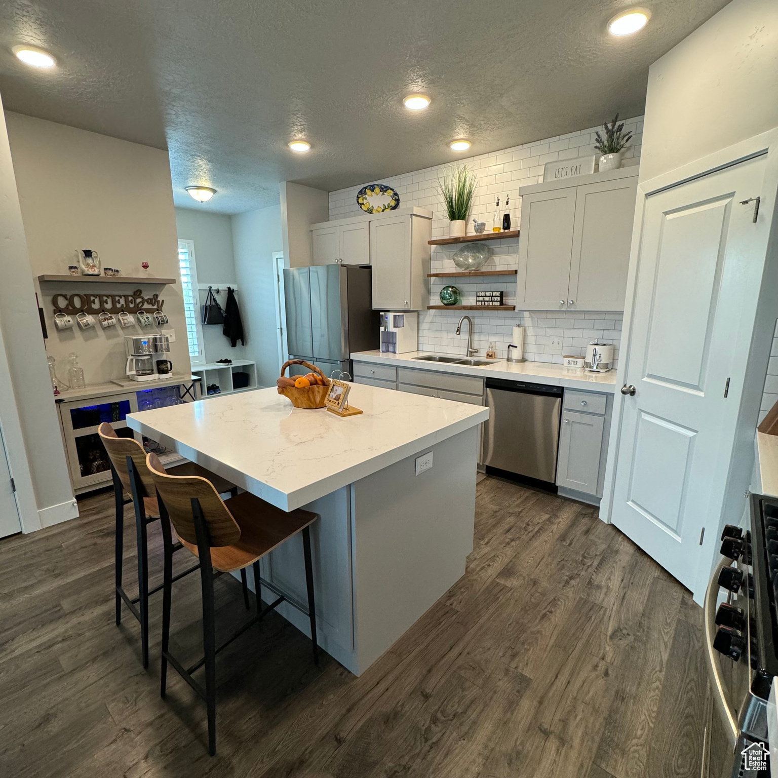 Kitchen featuring a kitchen island, sink, dark hardwood / wood-style flooring, stainless steel appliances, and a kitchen breakfast bar