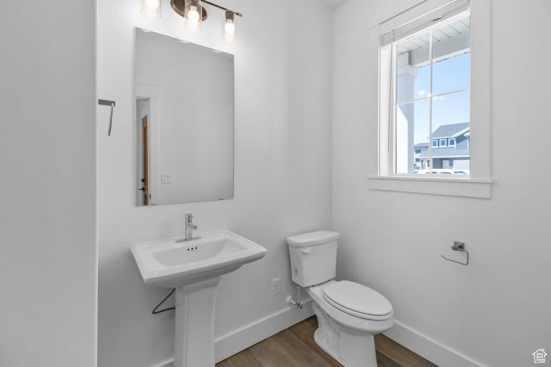 Bathroom featuring hardwood / wood-style flooring, toilet, and sink