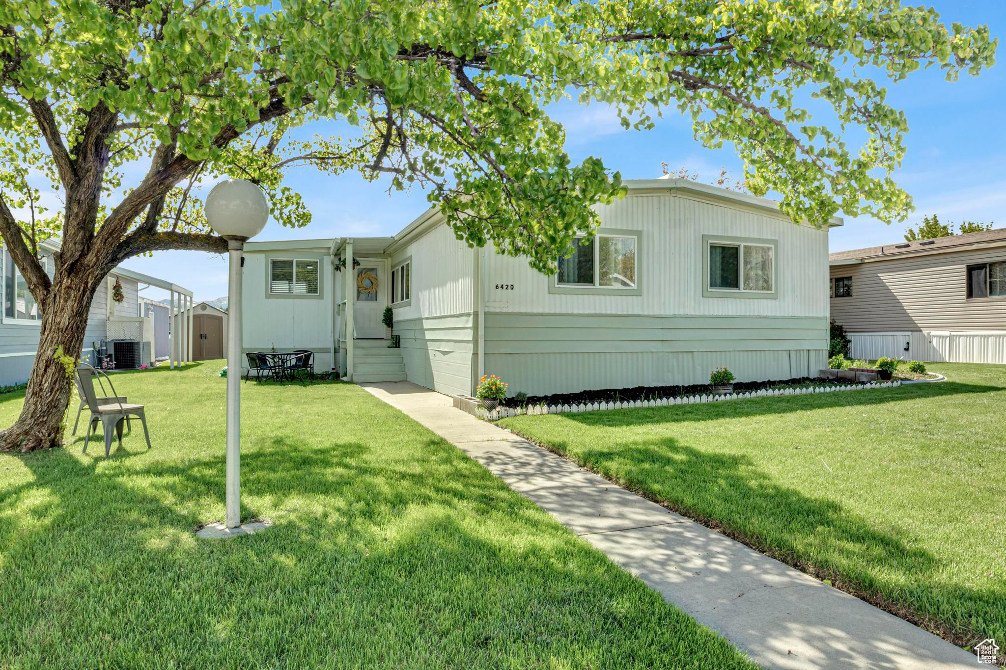 Manufactured / mobile home with central AC unit and a front yard