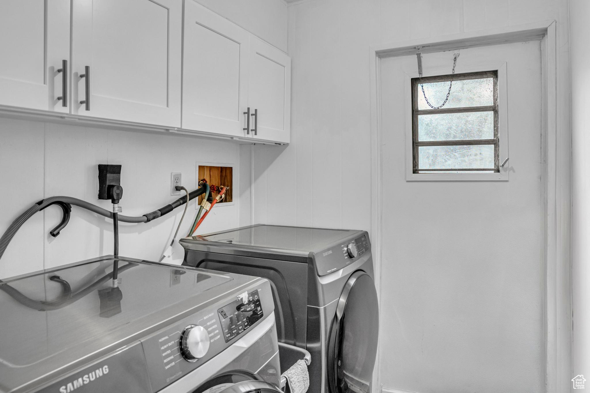 Laundry room featuring electric dryer hookup, cabinets, washer hookup, and washing machine and clothes dryer