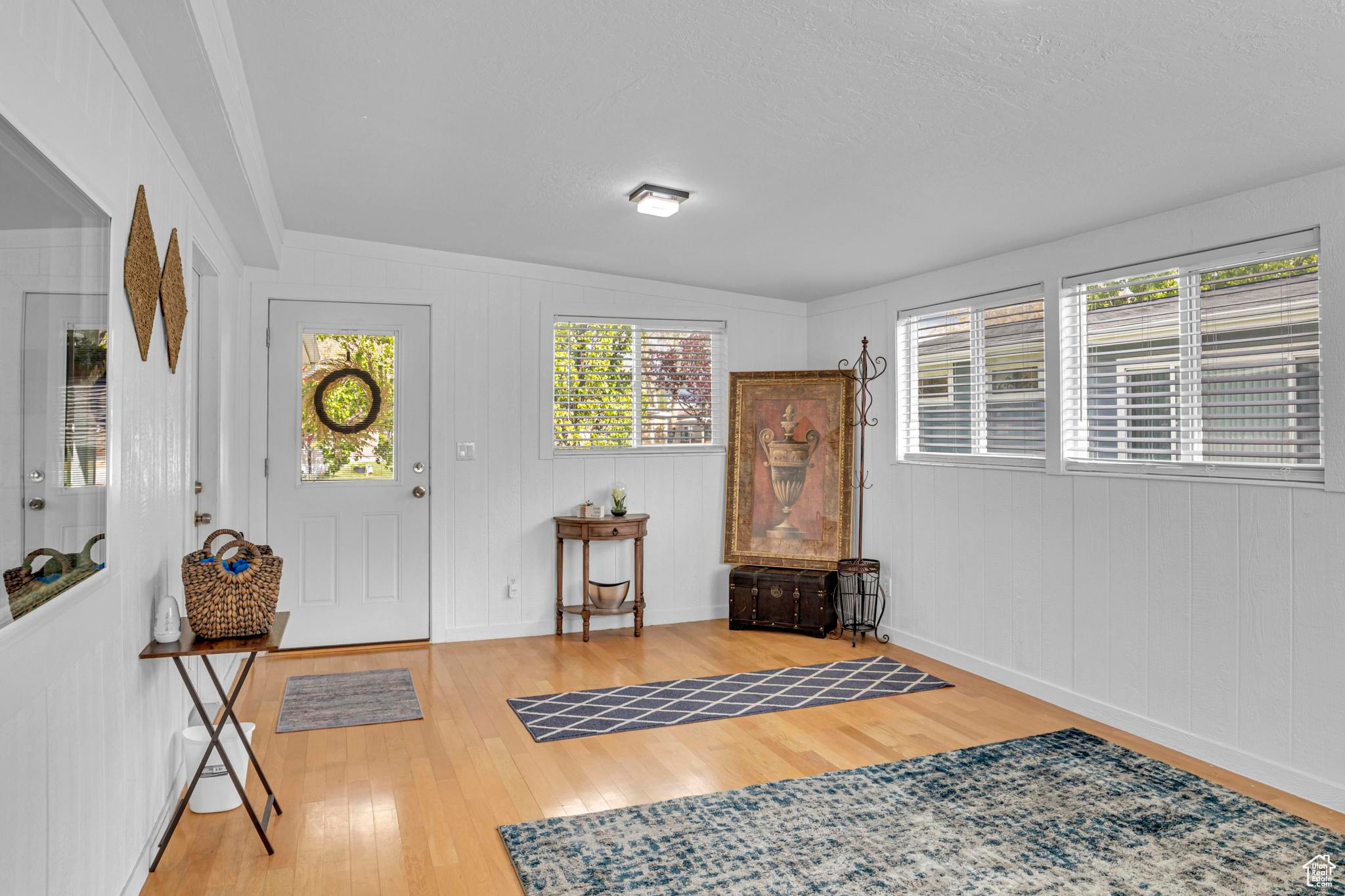 Entrance foyer with lofted ceiling and hardwood / wood-style flooring