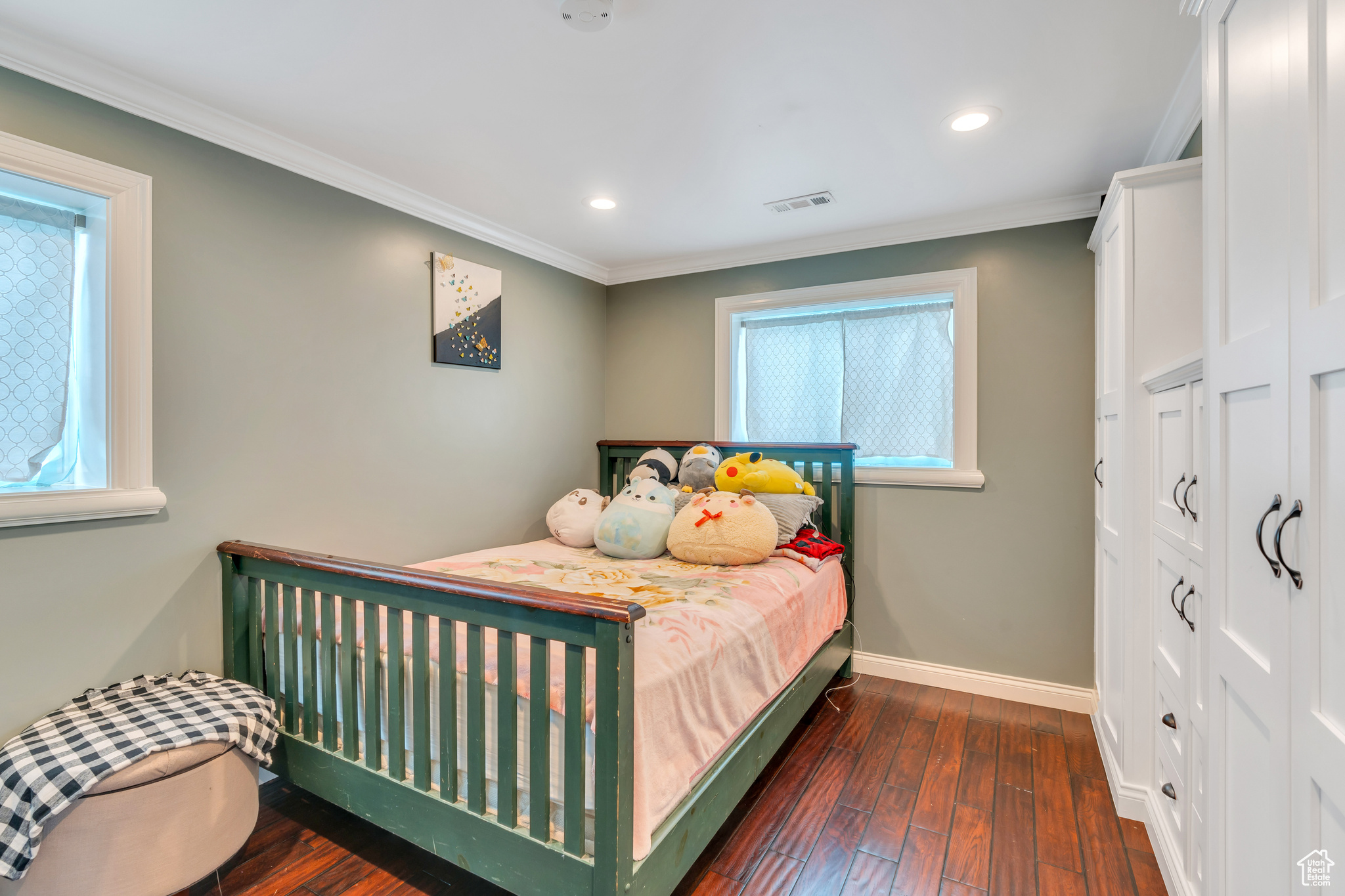 Bedroom featuring dark hardwood / wood-style floors, ornamental molding, and multiple windows