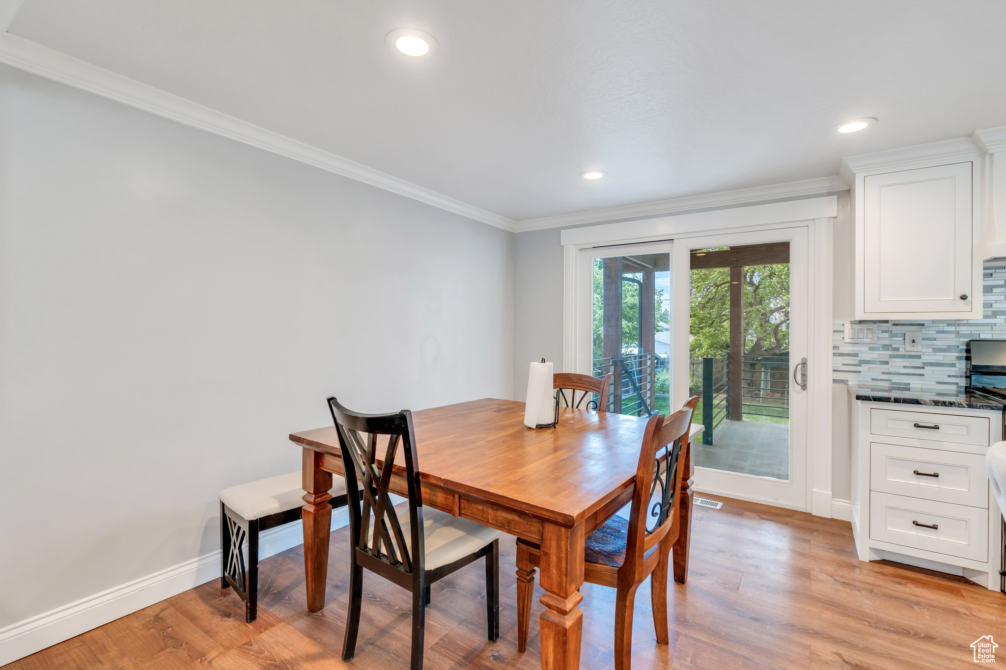 Dining area with crown molding and light wood-type flooring