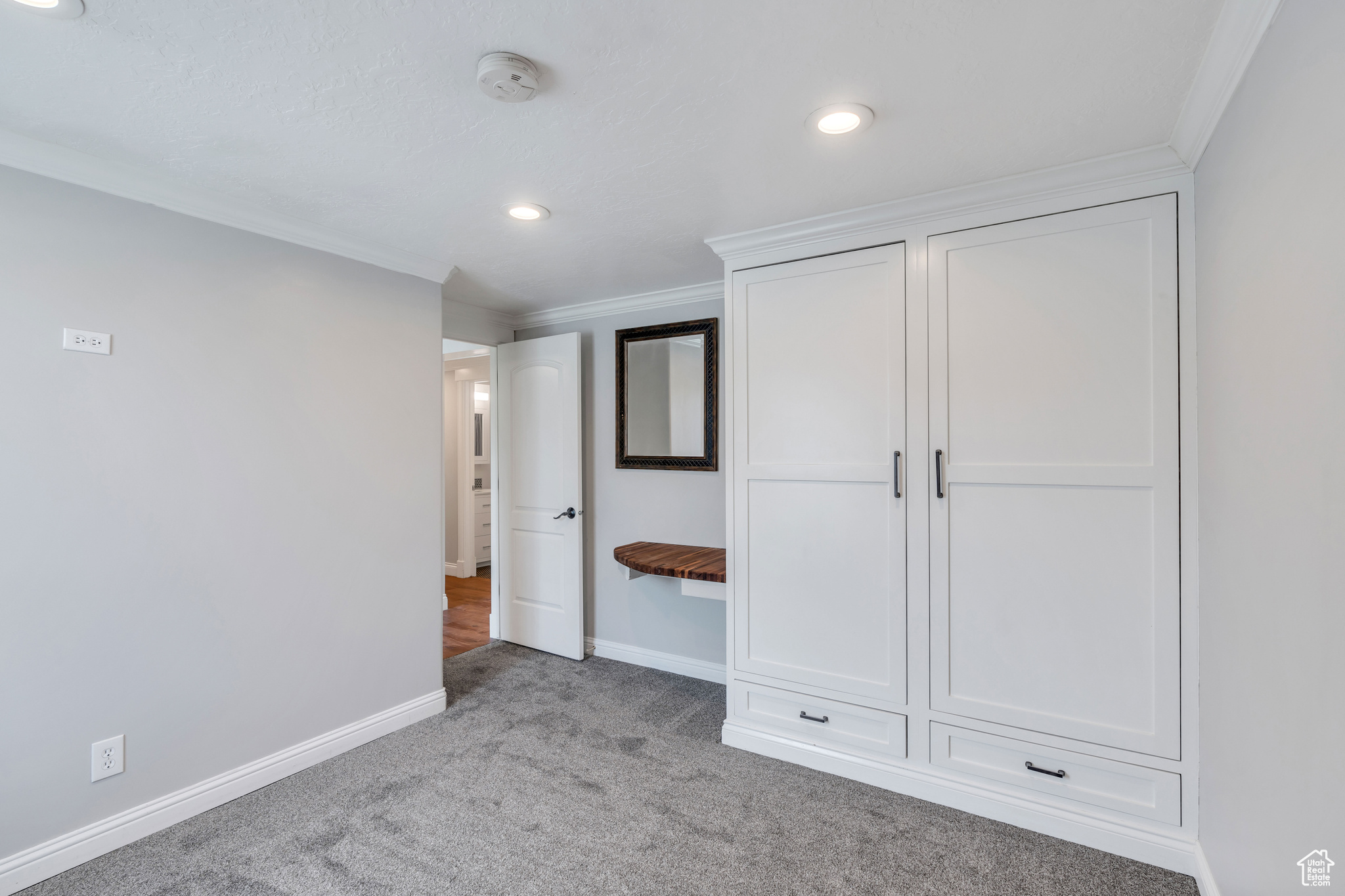Unfurnished bedroom featuring carpet floors and crown molding