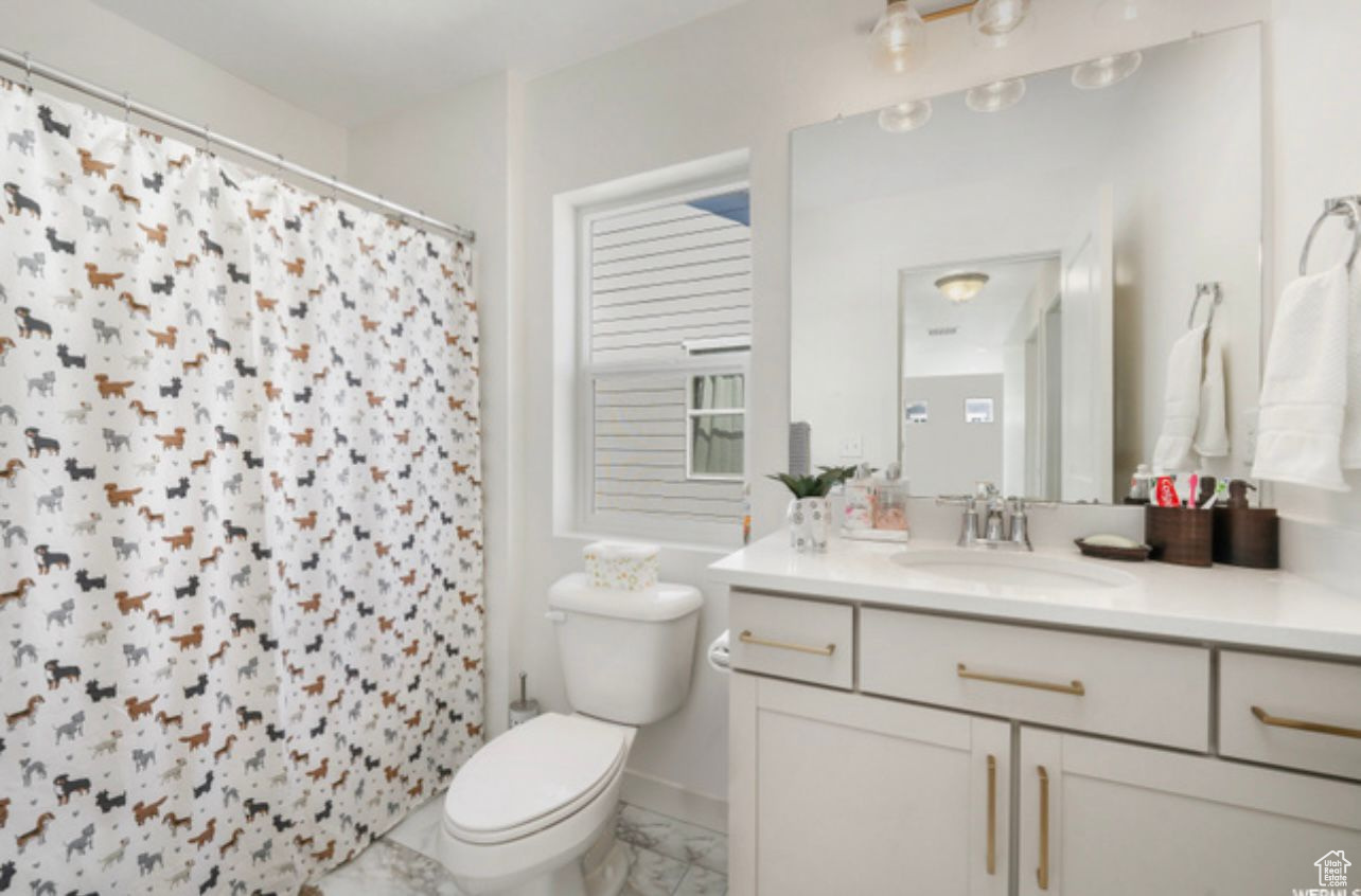 Bathroom with vanity, tile floors, and toilet