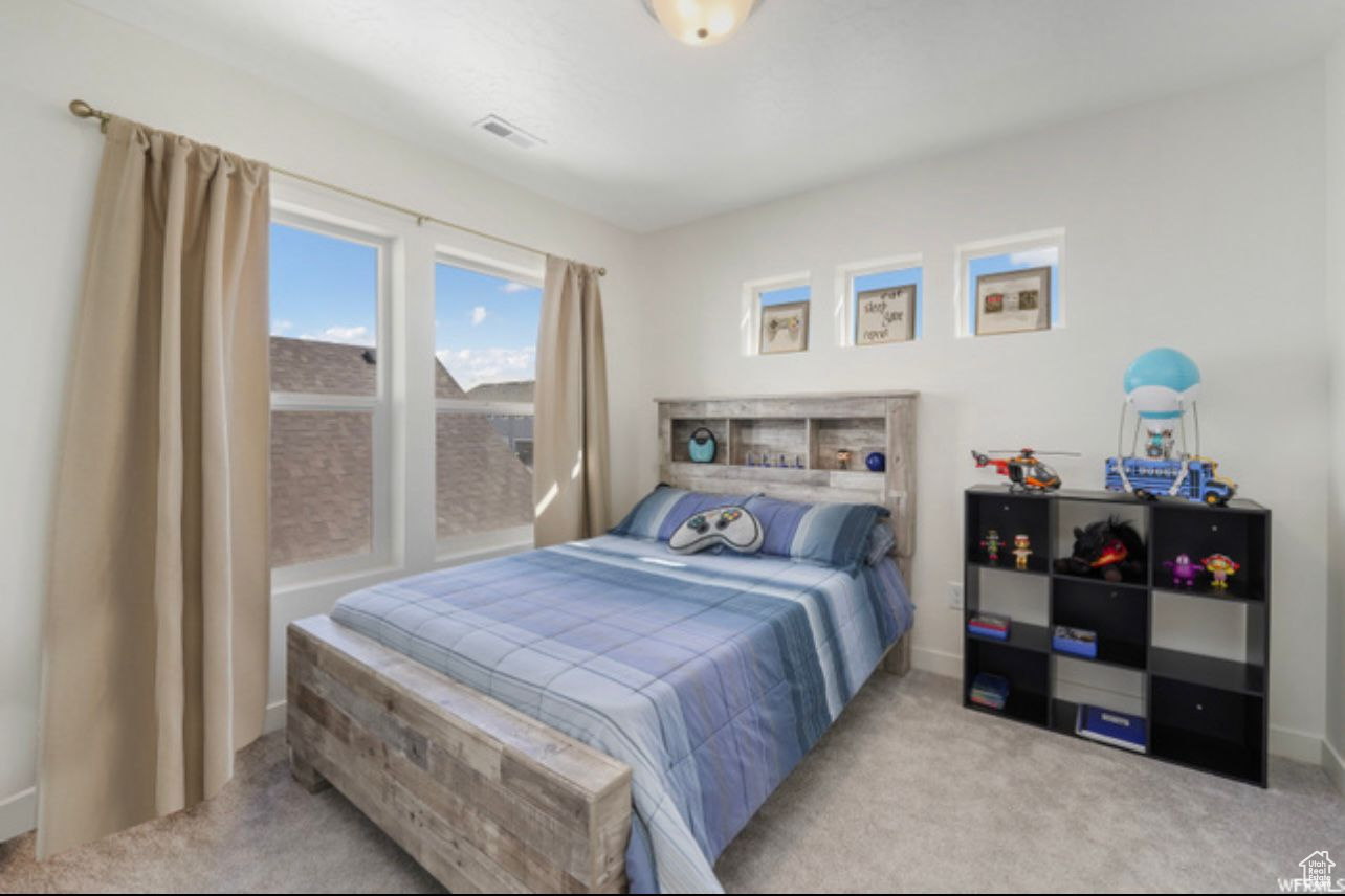 Bedroom featuring light colored carpet