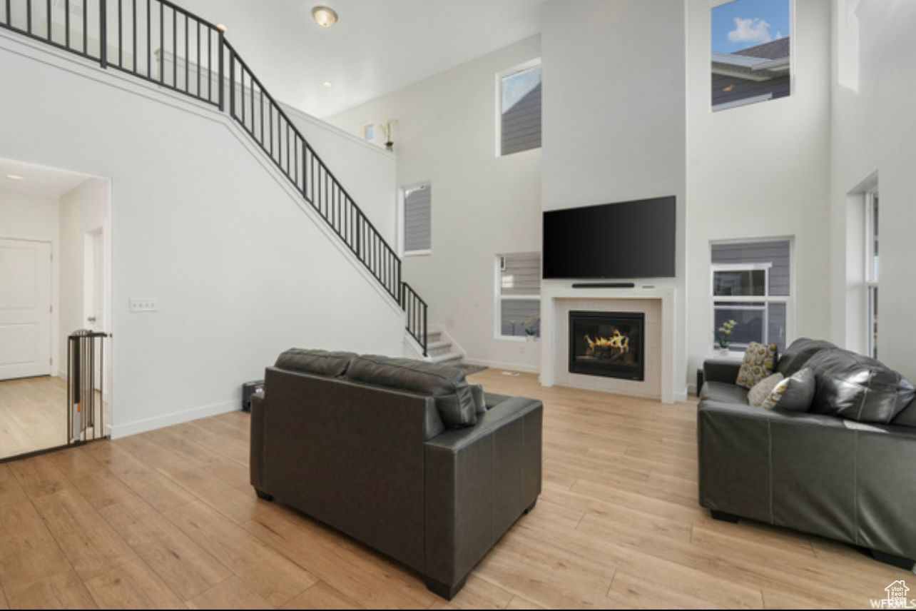 Living room with a high ceiling and light wood-type flooring