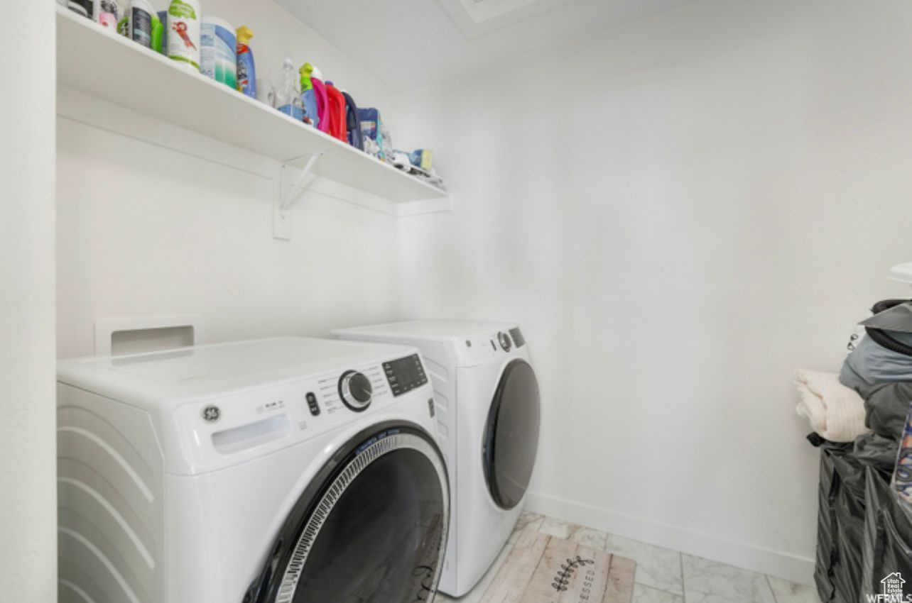 Washroom featuring light tile flooring, hookup for a washing machine, and washer and clothes dryer