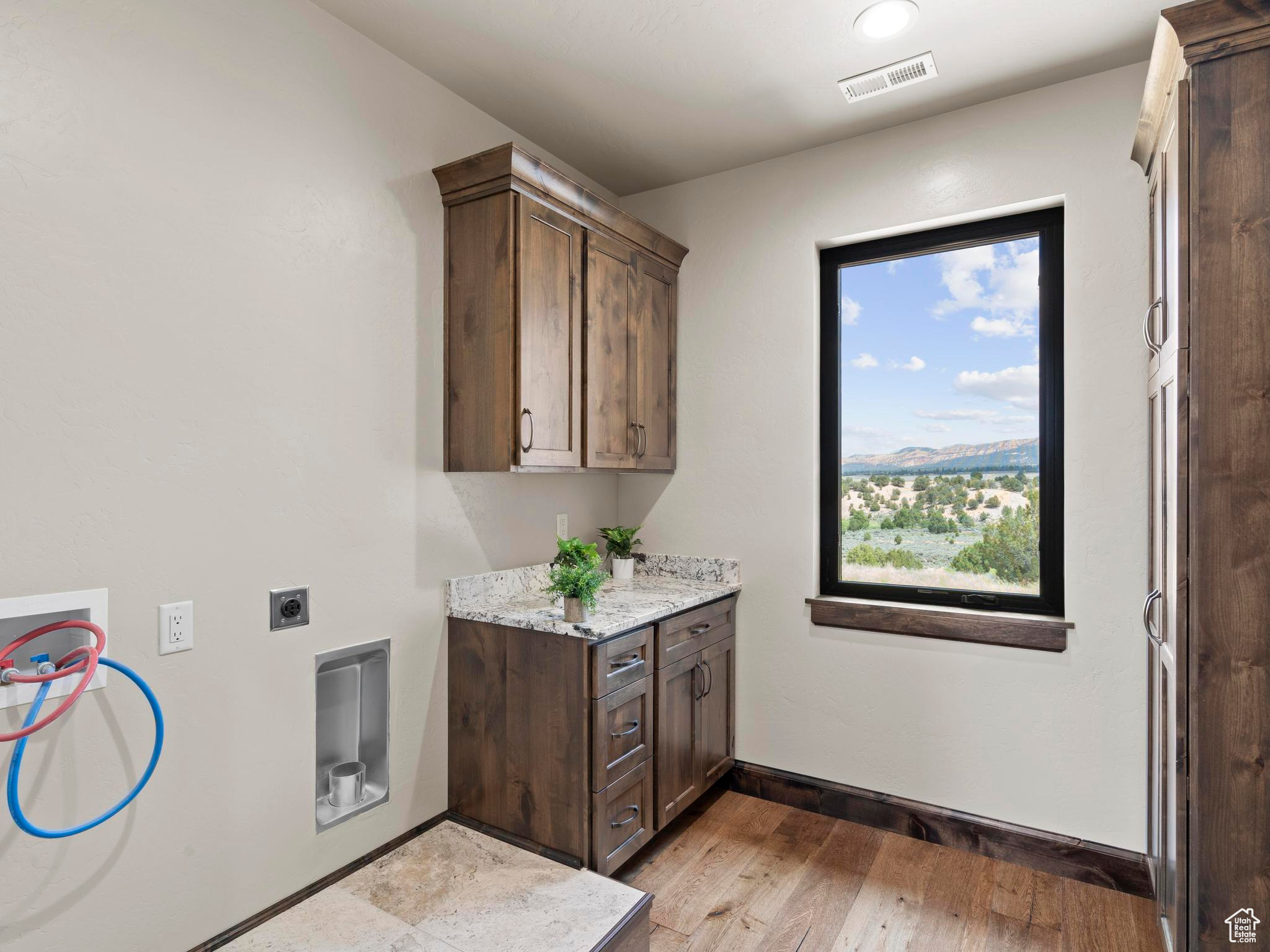 Laundry area with custom cabinets, natural light, washer hookup, electric dryer hookup.