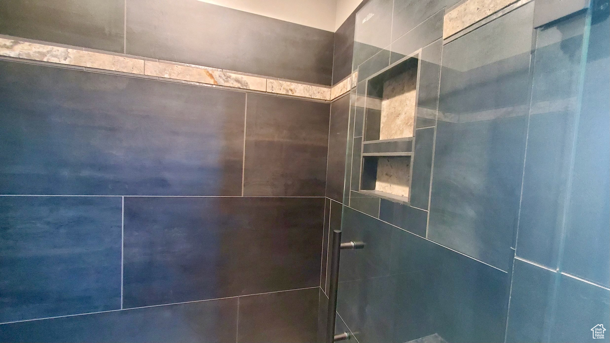 Owner's suite enlarged shower with custom tile work.