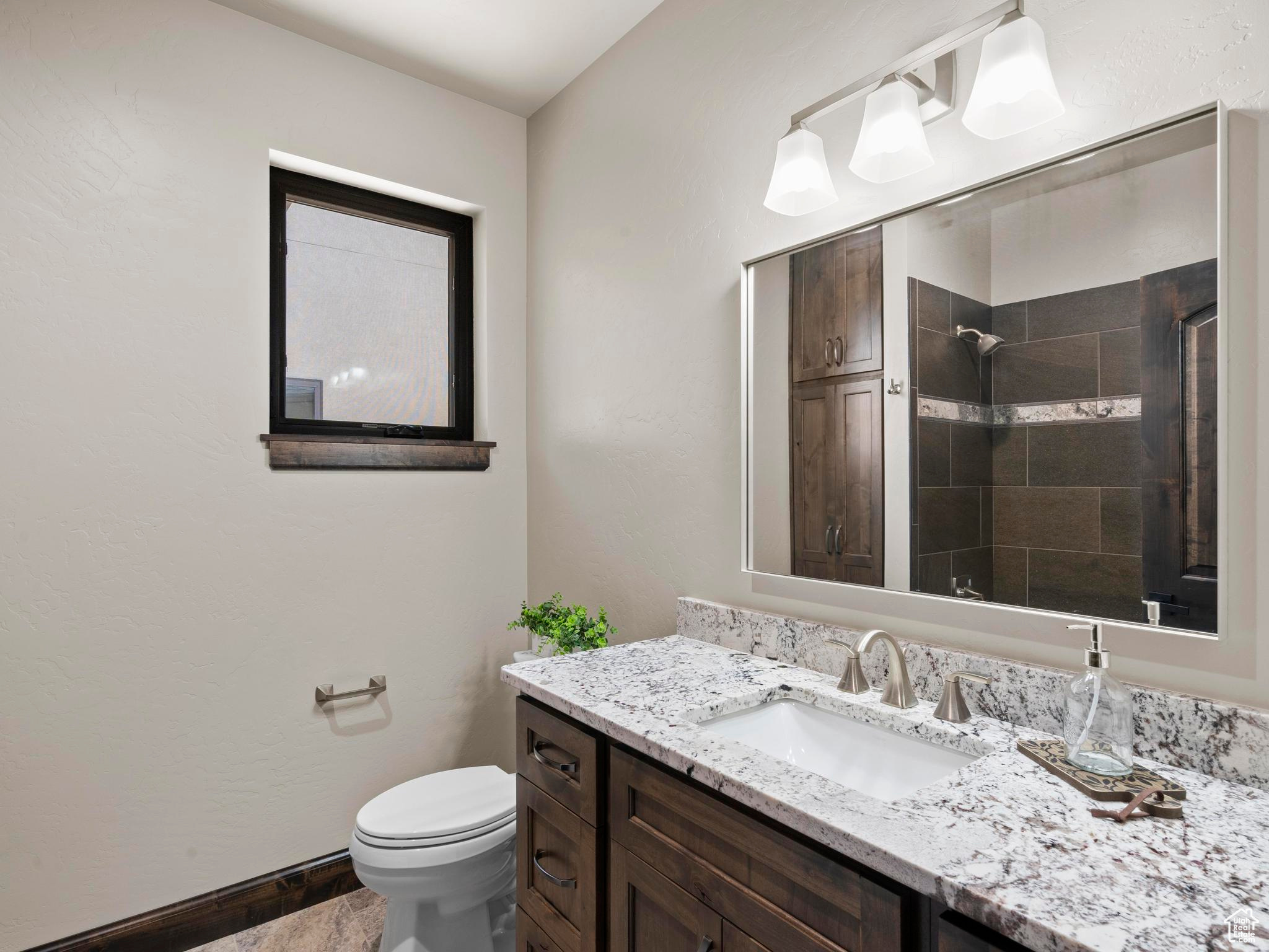 Bathroom with vanity with linen cabinet, custom tile surround and floor.