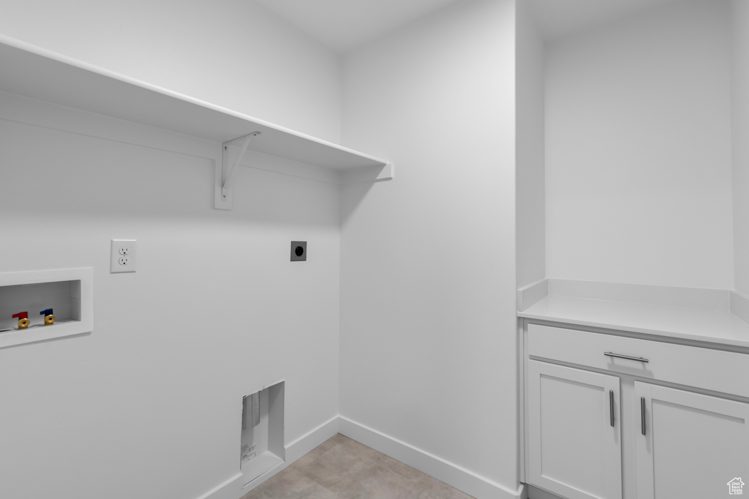 Laundry area with washer hookup, electric dryer hookup, cabinets, and light tile flooring