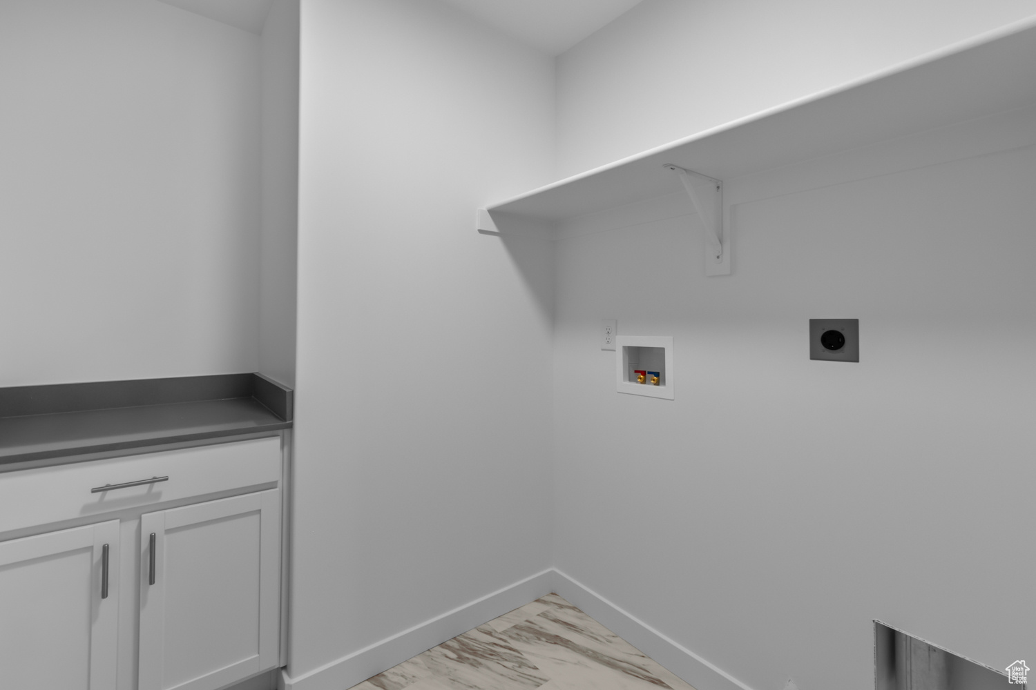 Washroom with hookup for an electric dryer, cabinets, and washer hookup