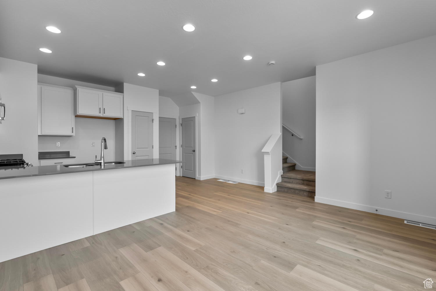 Kitchen featuring light hardwood / wood-style floors, white cabinets, and sink