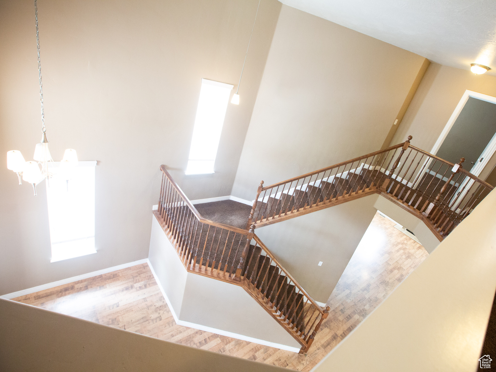 Stairs with wood-type flooring, a wealth of natural light, and a towering ceiling