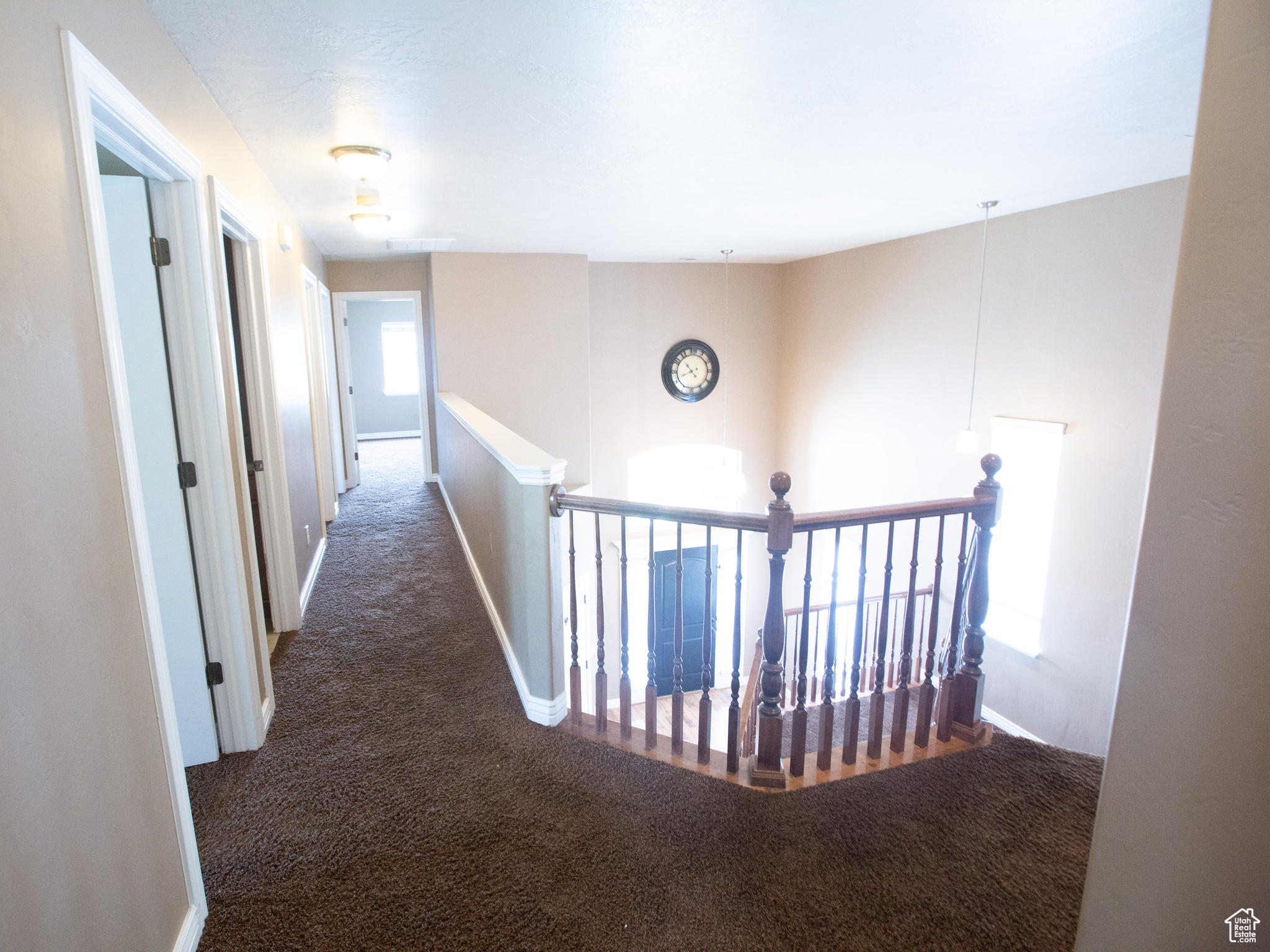 Corridor with dark colored carpet and plenty of natural light