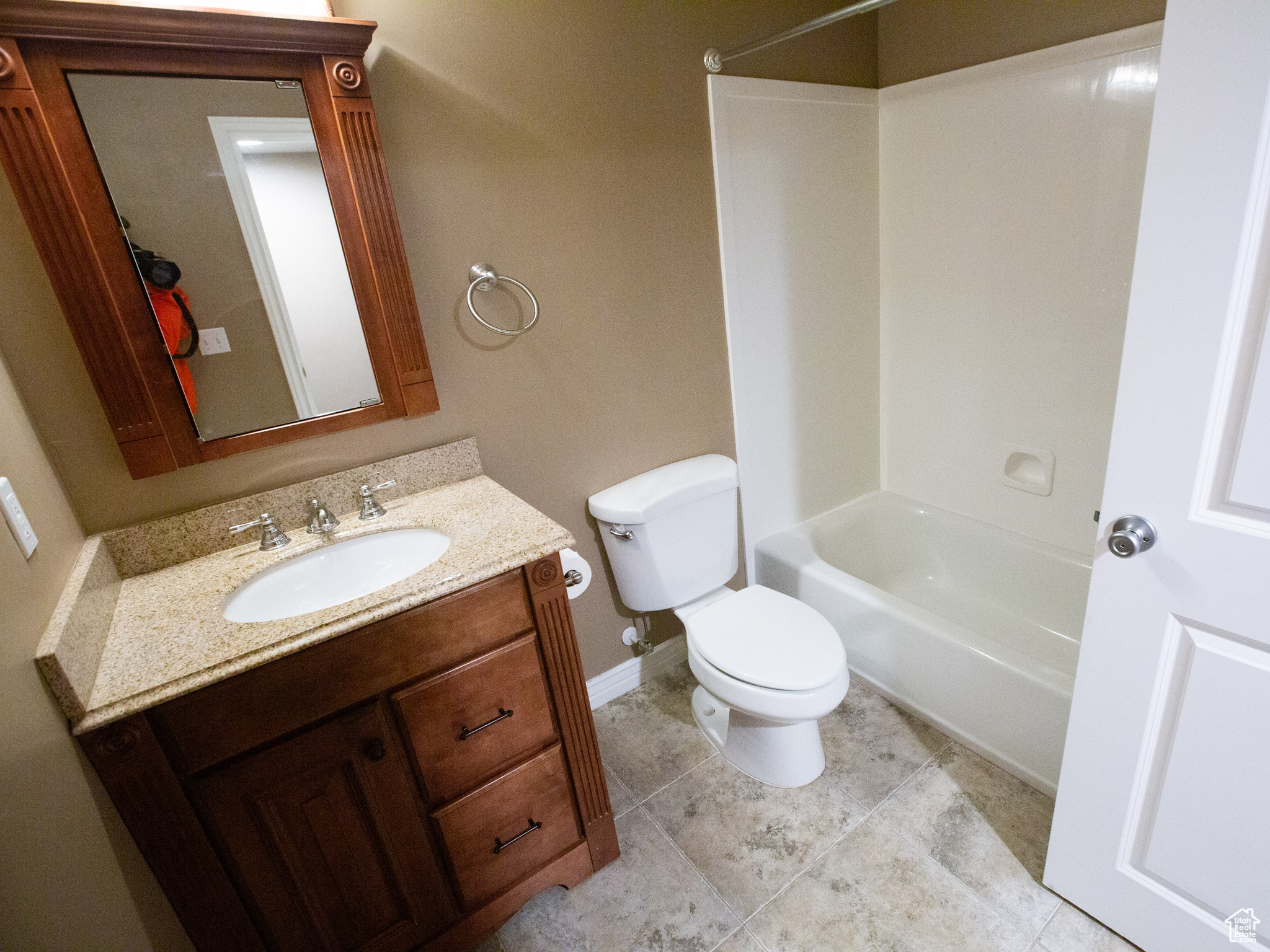 Full bathroom featuring tub / shower combination, toilet, tile floors, and vanity