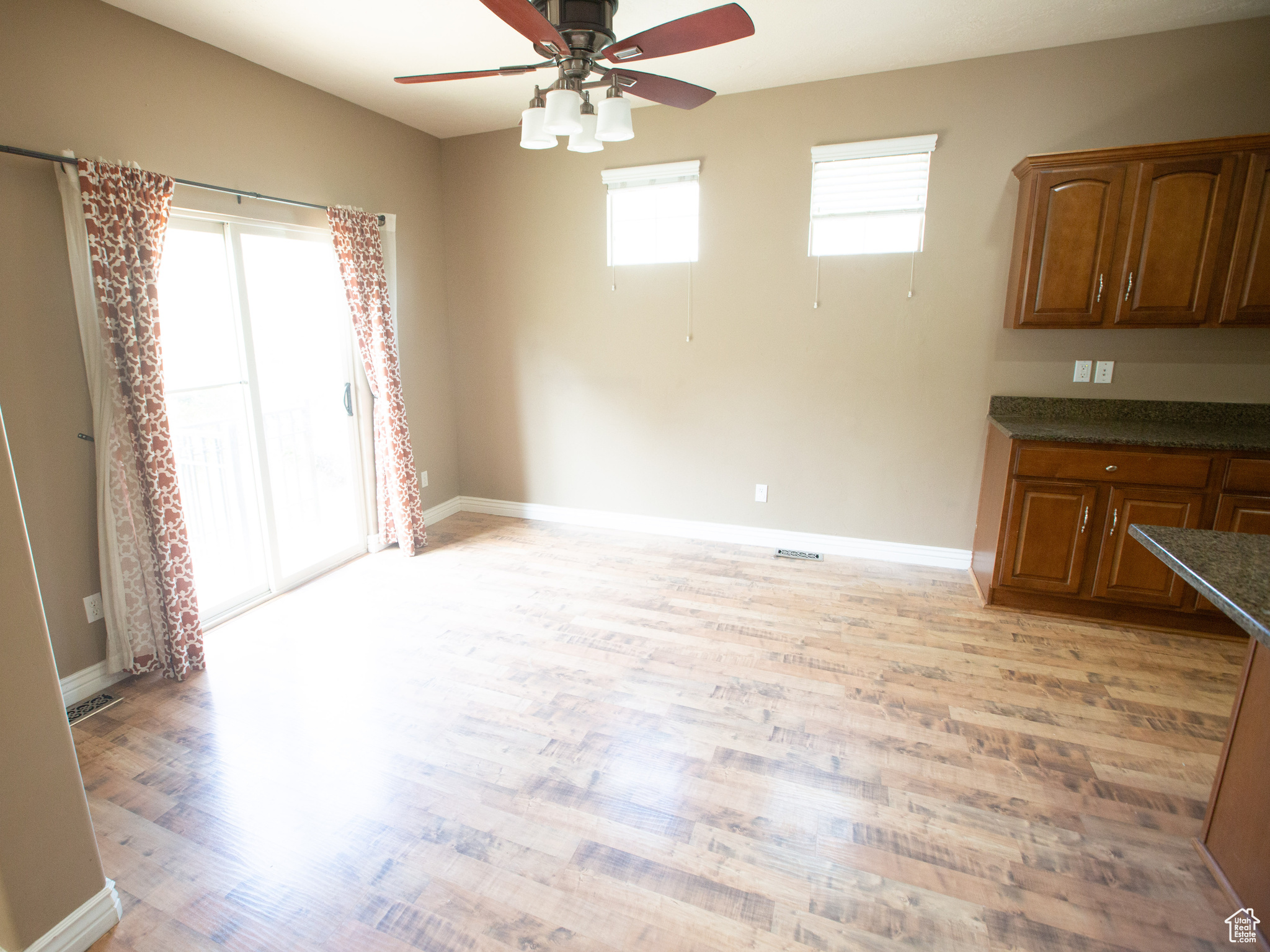 Unfurnished dining area featuring ceiling fan and light wood-type flooring