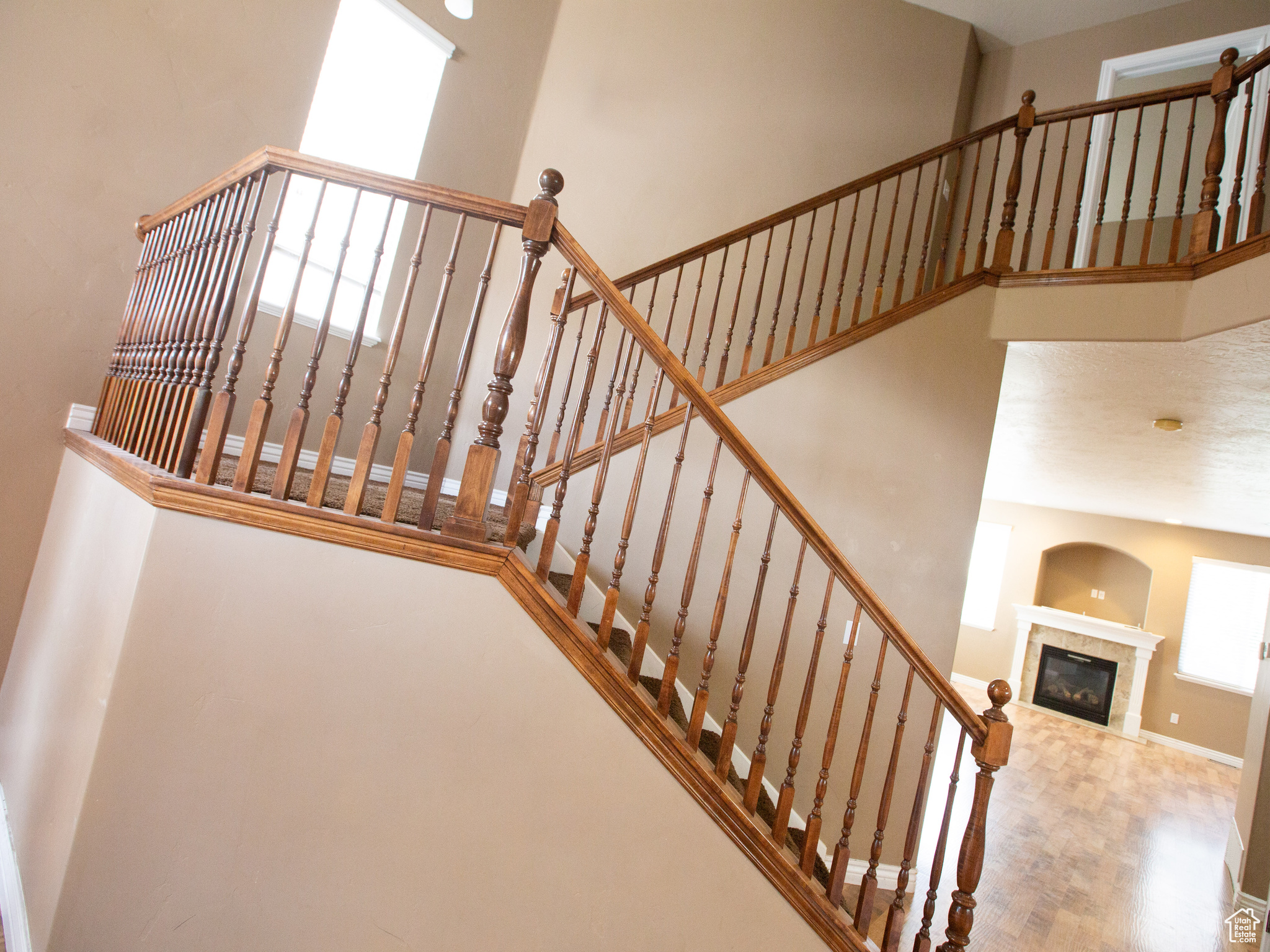 Staircase featuring a tiled fireplace and a high ceiling