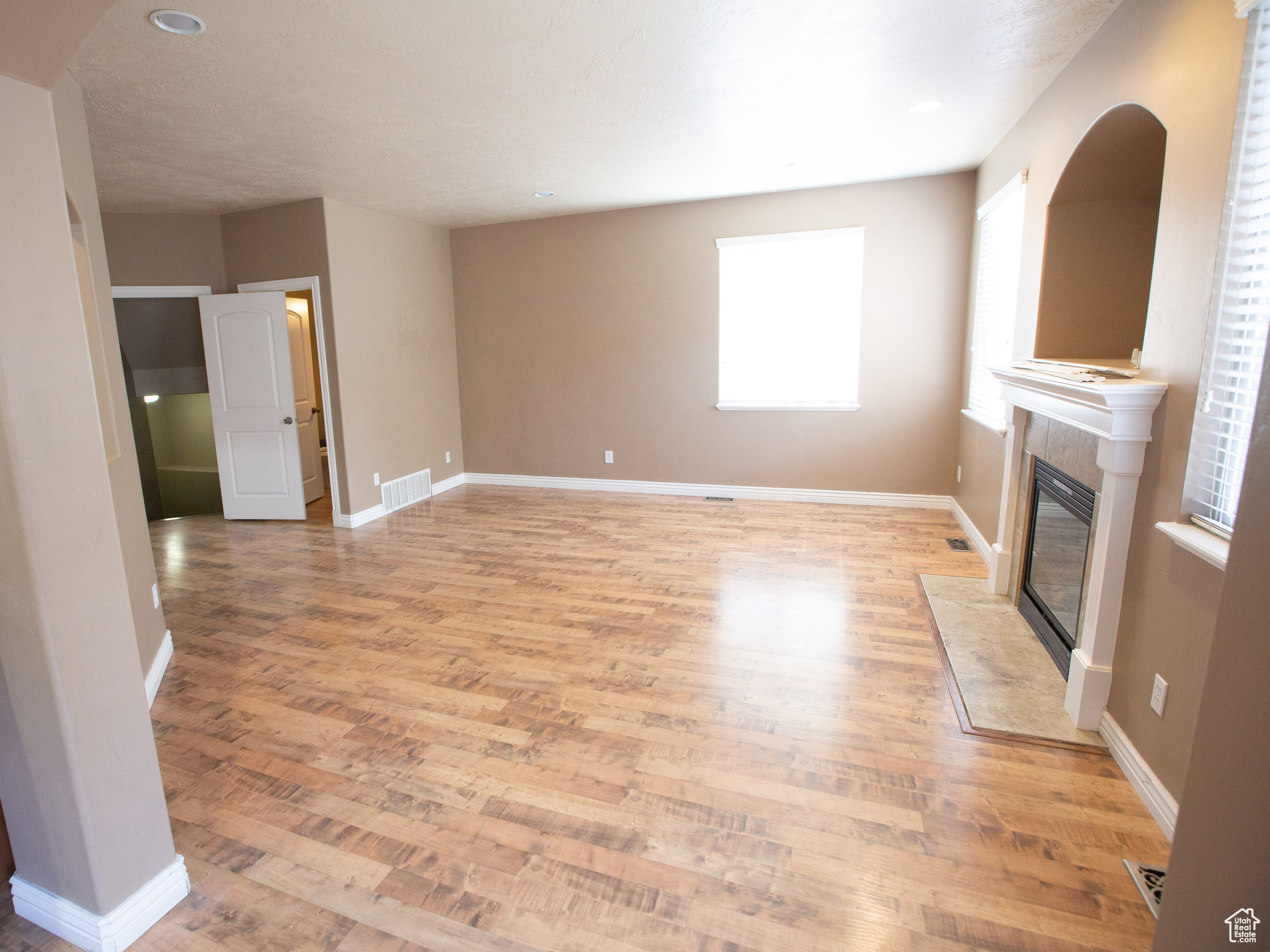 Unfurnished living room featuring hardwood / wood-style floors and a premium fireplace