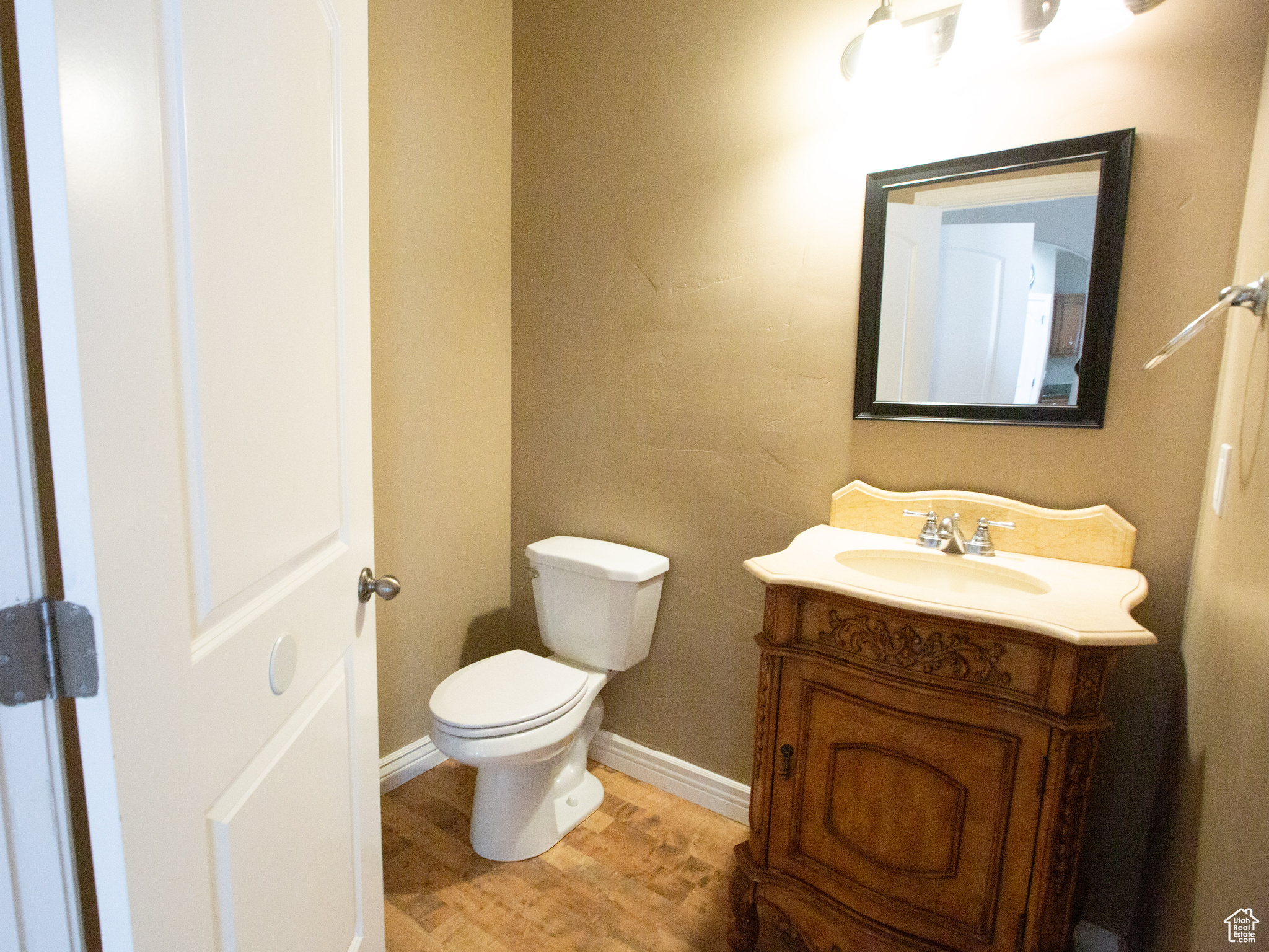 Bathroom with hardwood / wood-style flooring, toilet, and vanity