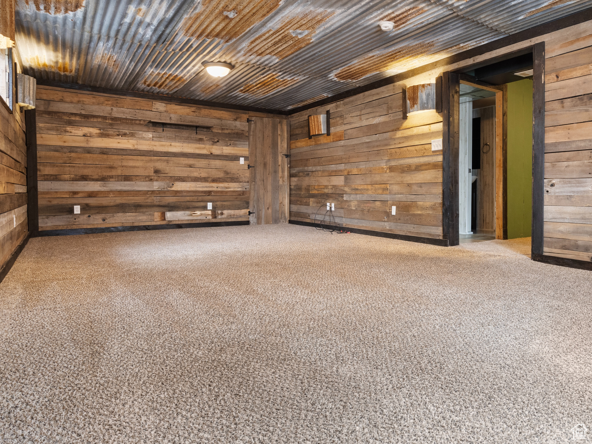Spare room featuring wood ceiling, wood walls, and carpet flooring